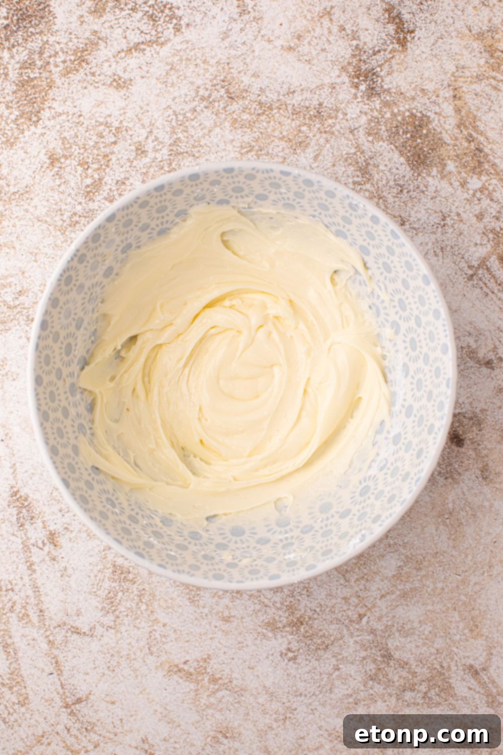 Effortless 2-Ingredient Pumpkin Cinnamon Rolls No Yeast 14 powdered sugar glaze in a white bowl sitting on counter
