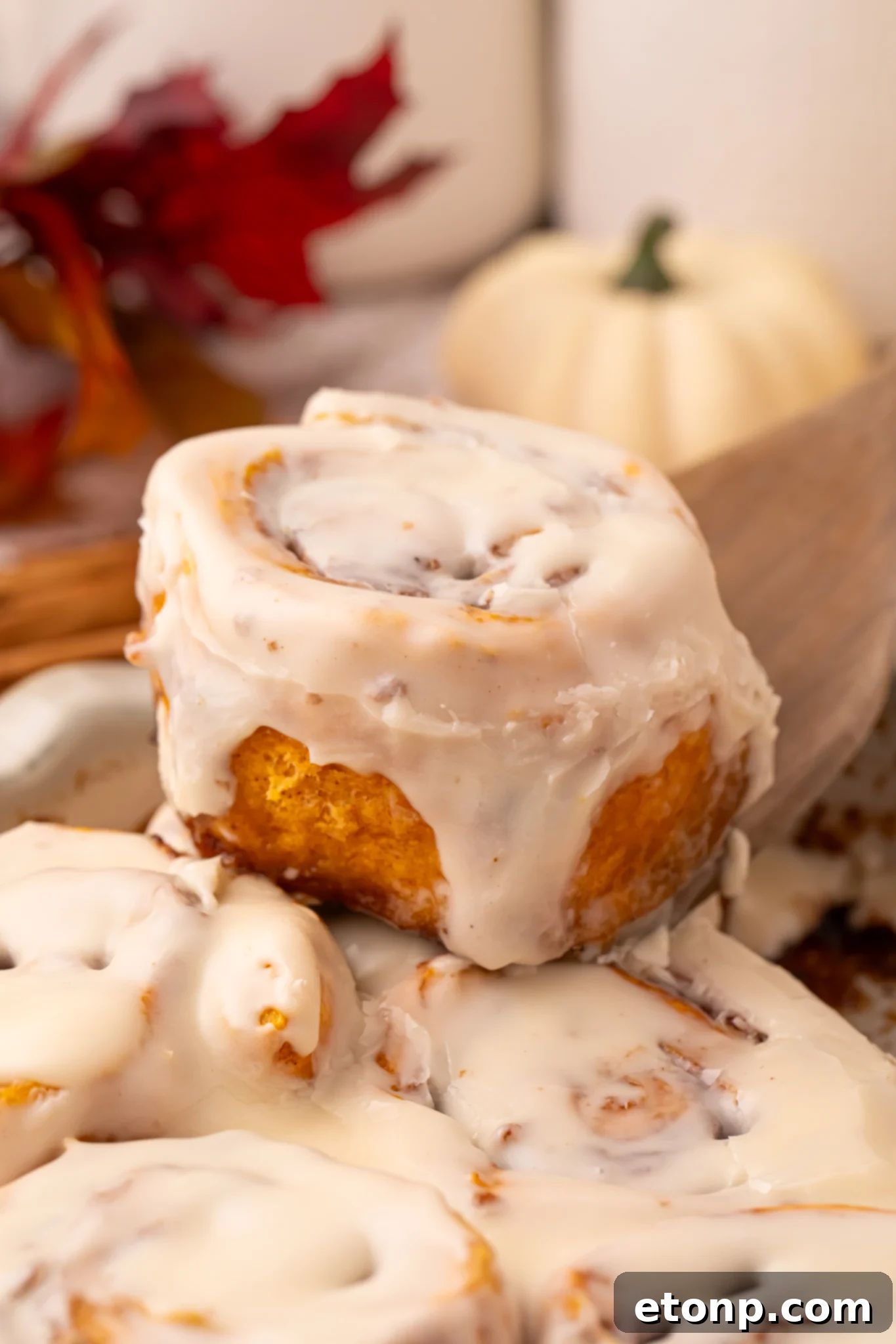 Effortless 2-Ingredient Pumpkin Cinnamon Rolls No Yeast 27 Easy 2 Ingredient Pumpkin Cinnamon Roll being lifted out of the baking dish
