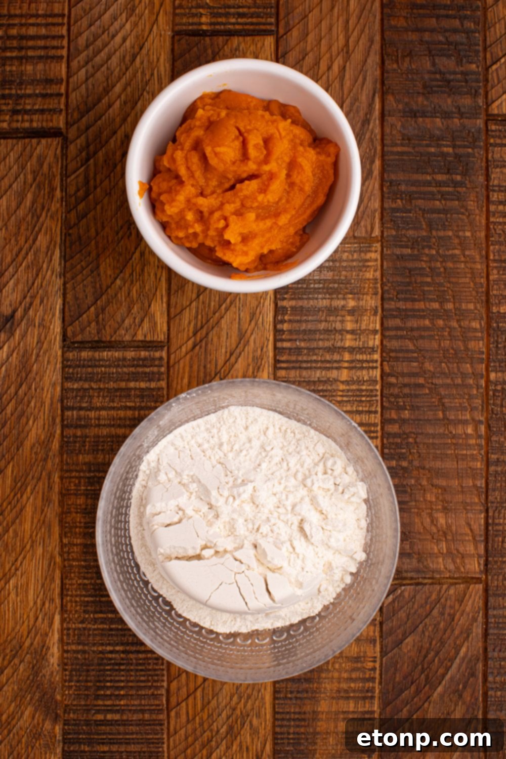 Effortless Two-Ingredient Pumpkin Pie Bites 5 self rising flour in a glass bowl and a bowl of pumpkin puree in a white bowl on wooden table