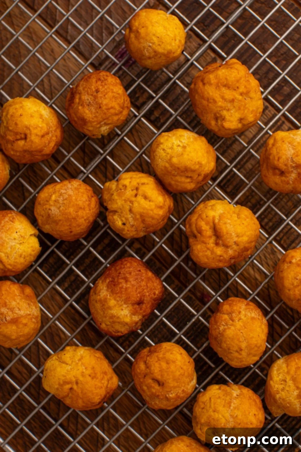 Effortless Two-Ingredient Pumpkin Pie Bites 7 wire tray with a bunch of fried Pumpkin Pie Donut Holes