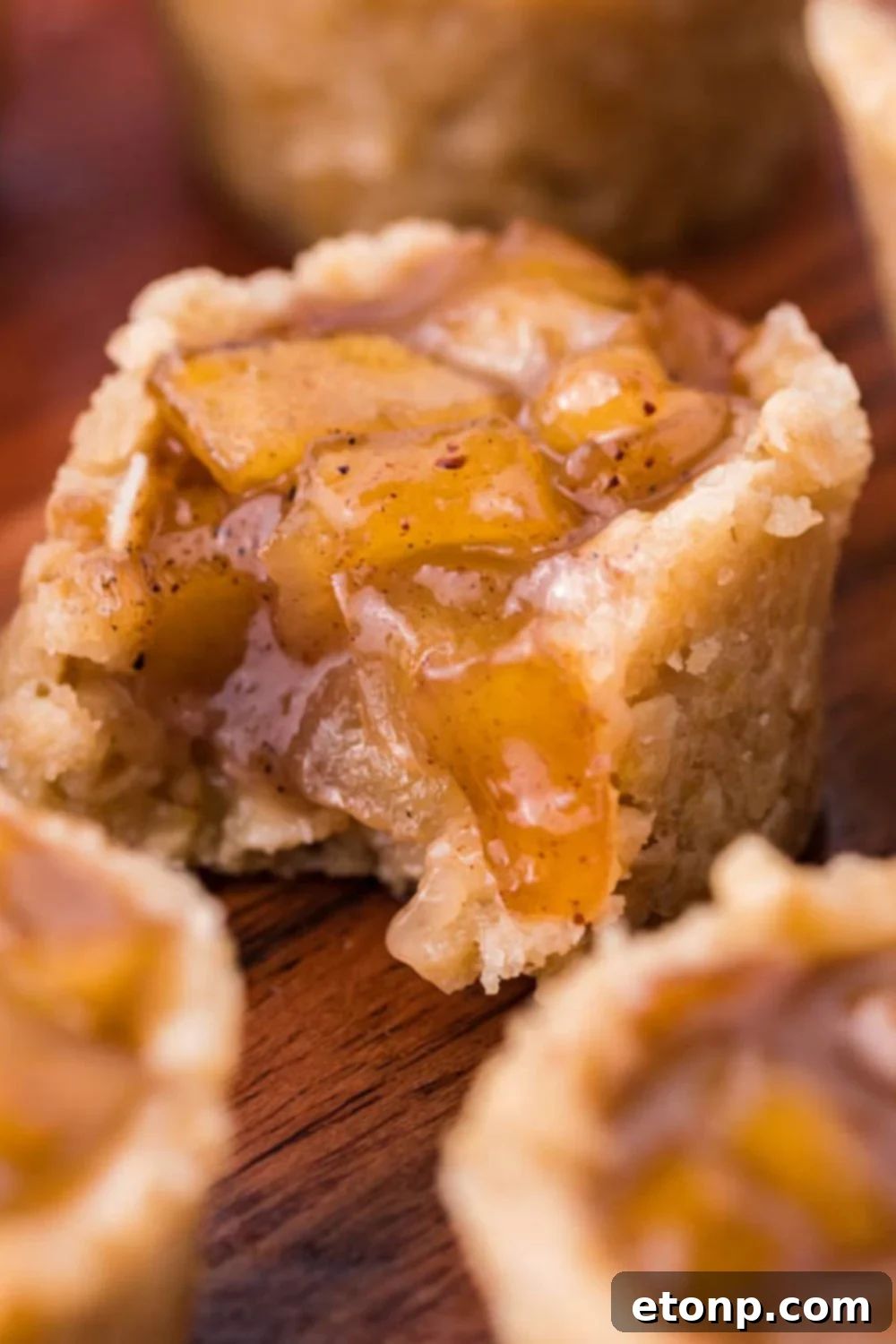 Mini Apple Crisp Bites on table and the one in the center has a bite taken out of it 