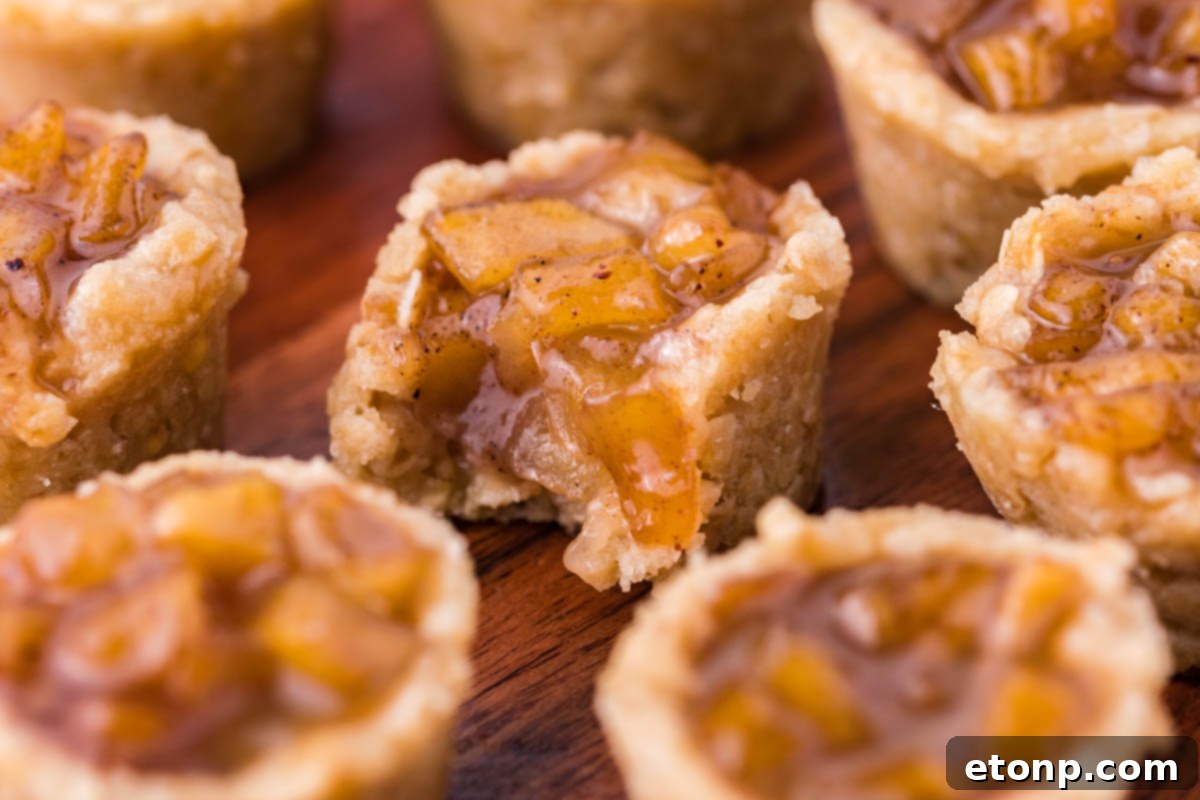 Mini Apple Crisp Bites on a wooden table with the center one missing a bite 
