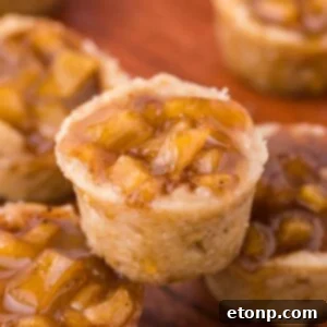Mini Apple Crisp Bites placed around a wooden table with one stacked on top of another one