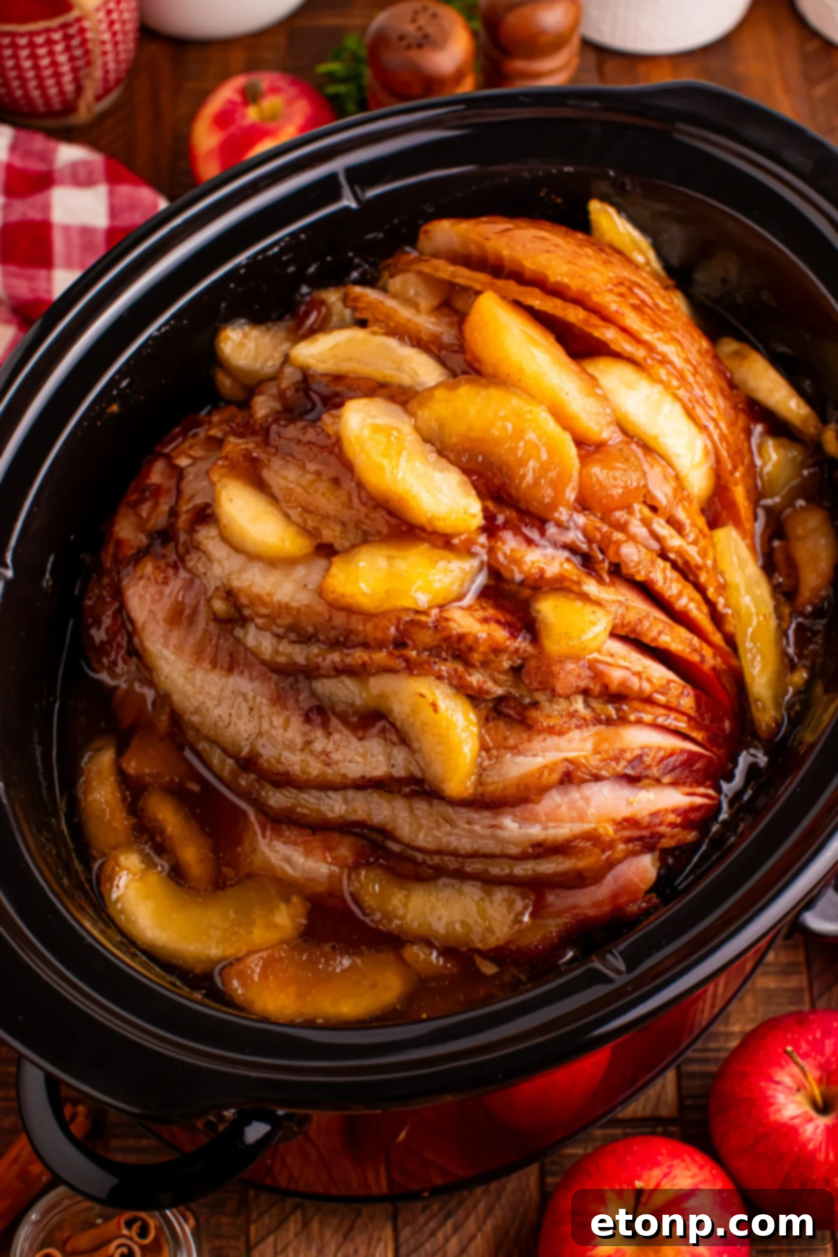 Up close shot of the Slow Cooker Apple Glazed Ham topped with apples 