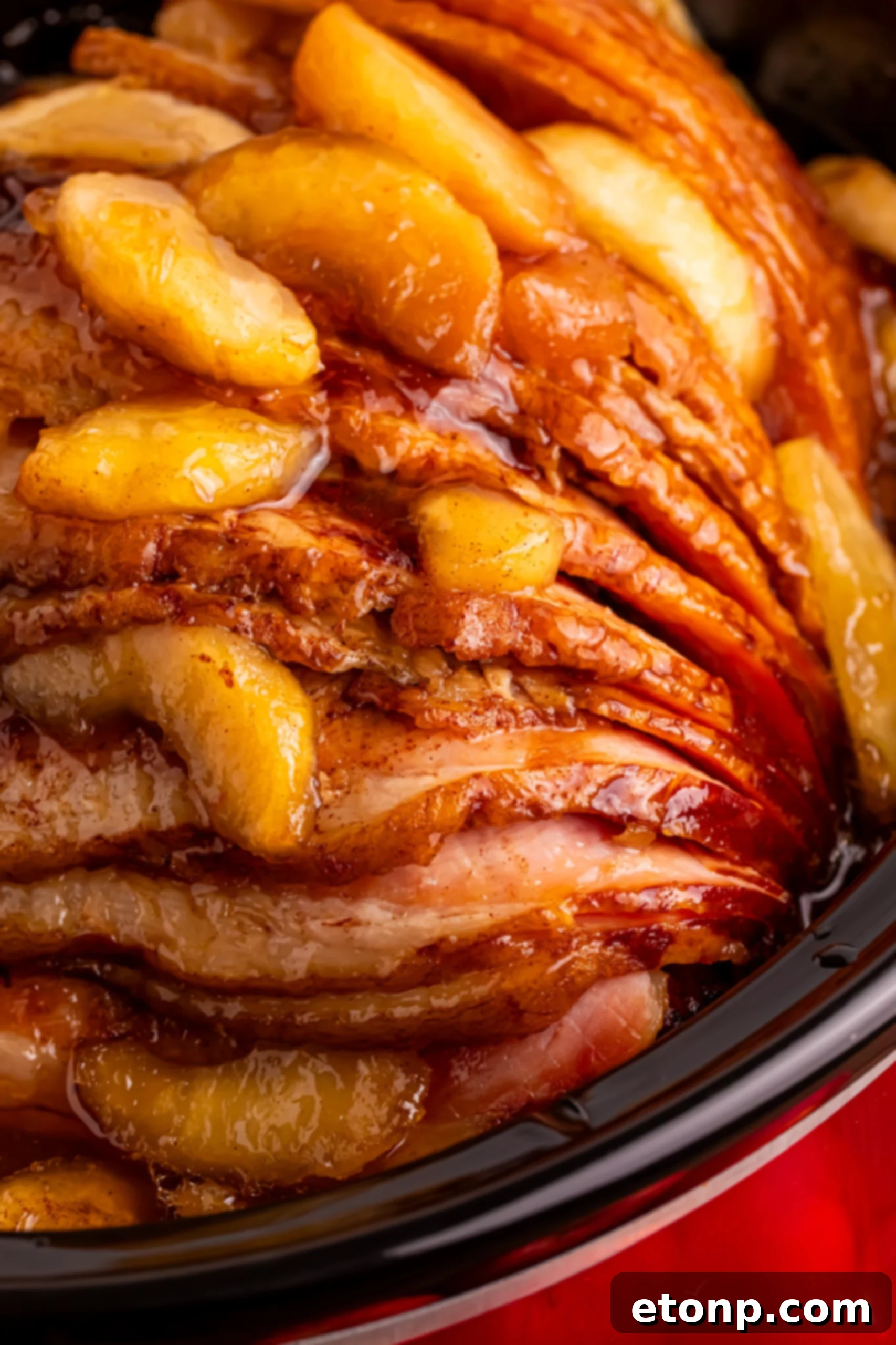 up close shot of the Slow Cooker Apple Glazed Ham in a black crock pot 