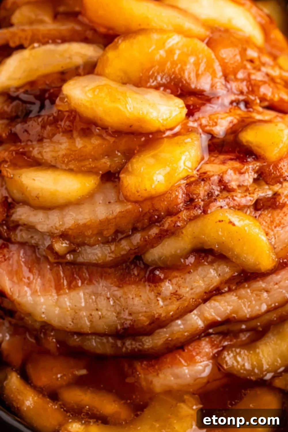 close up look of a cooked spiral cut ham with apple pie filling on top
