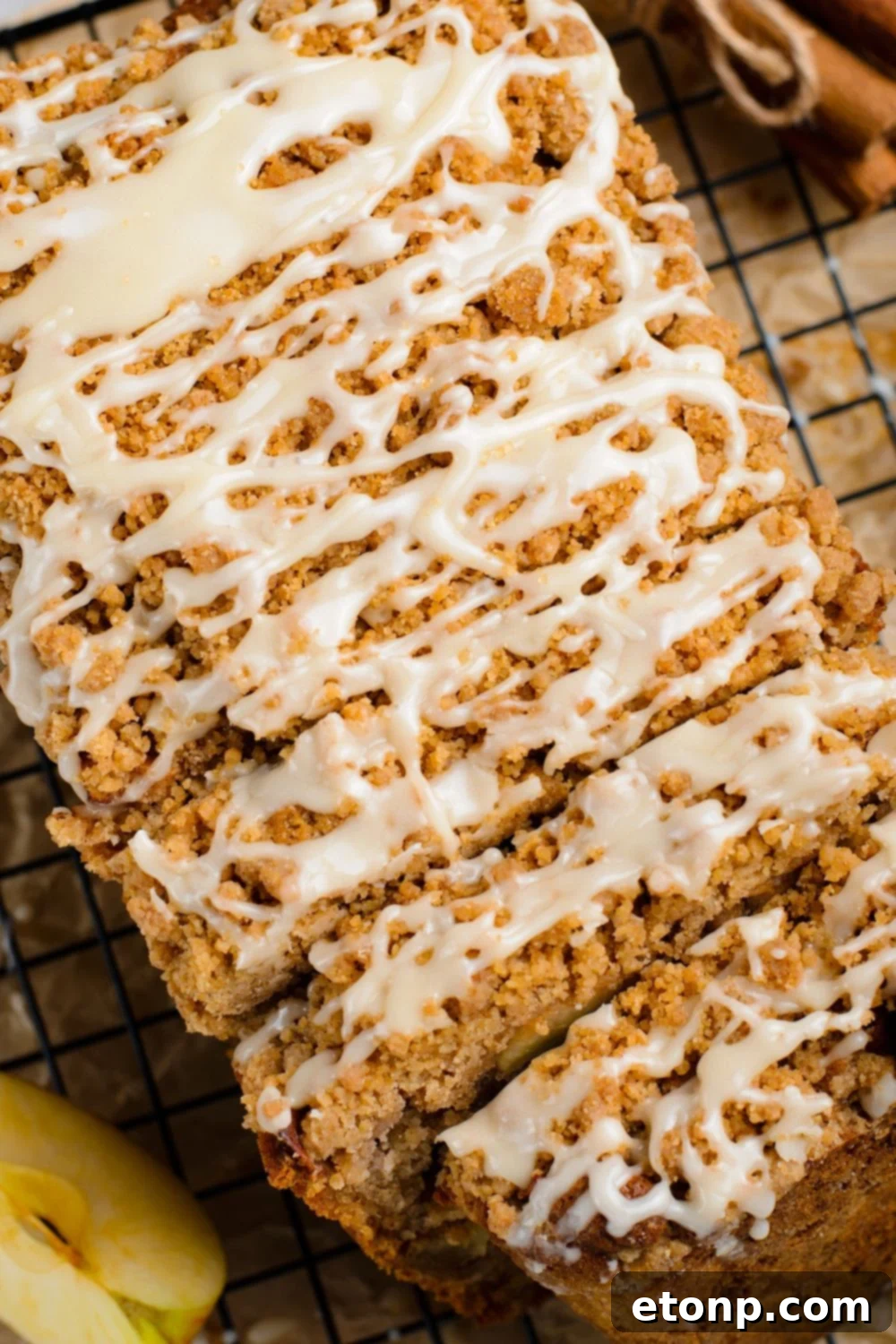 close up view of a Apple Cinnamon Loaf Cake on table with part of the loaf sliced into thick pieces