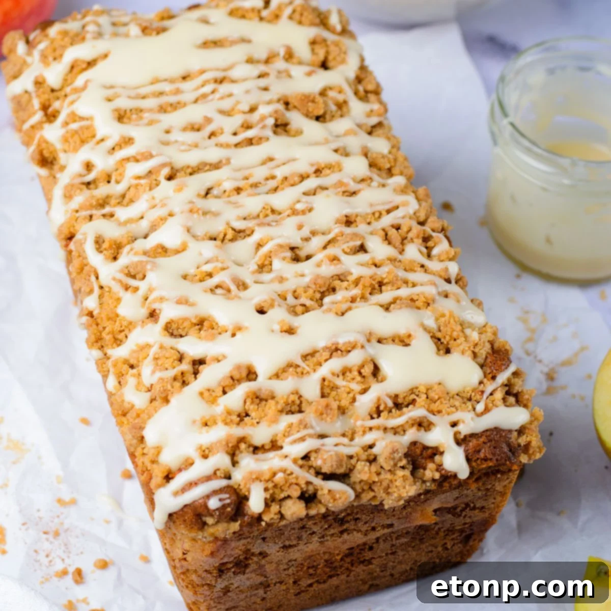 Apple Cinnamon Loaf Cake on the table with a jar that had glaze sitting next to it