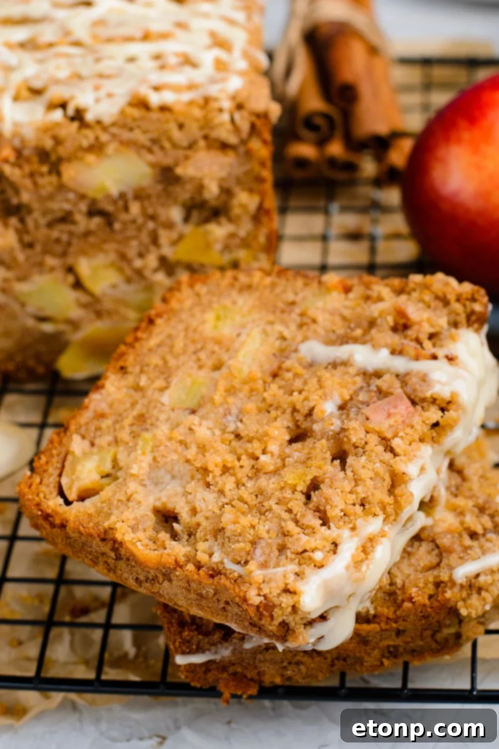 Apple Cinnamon Loaf Cake sliced and placed in a stack on table with a sweet glae drizzled on top