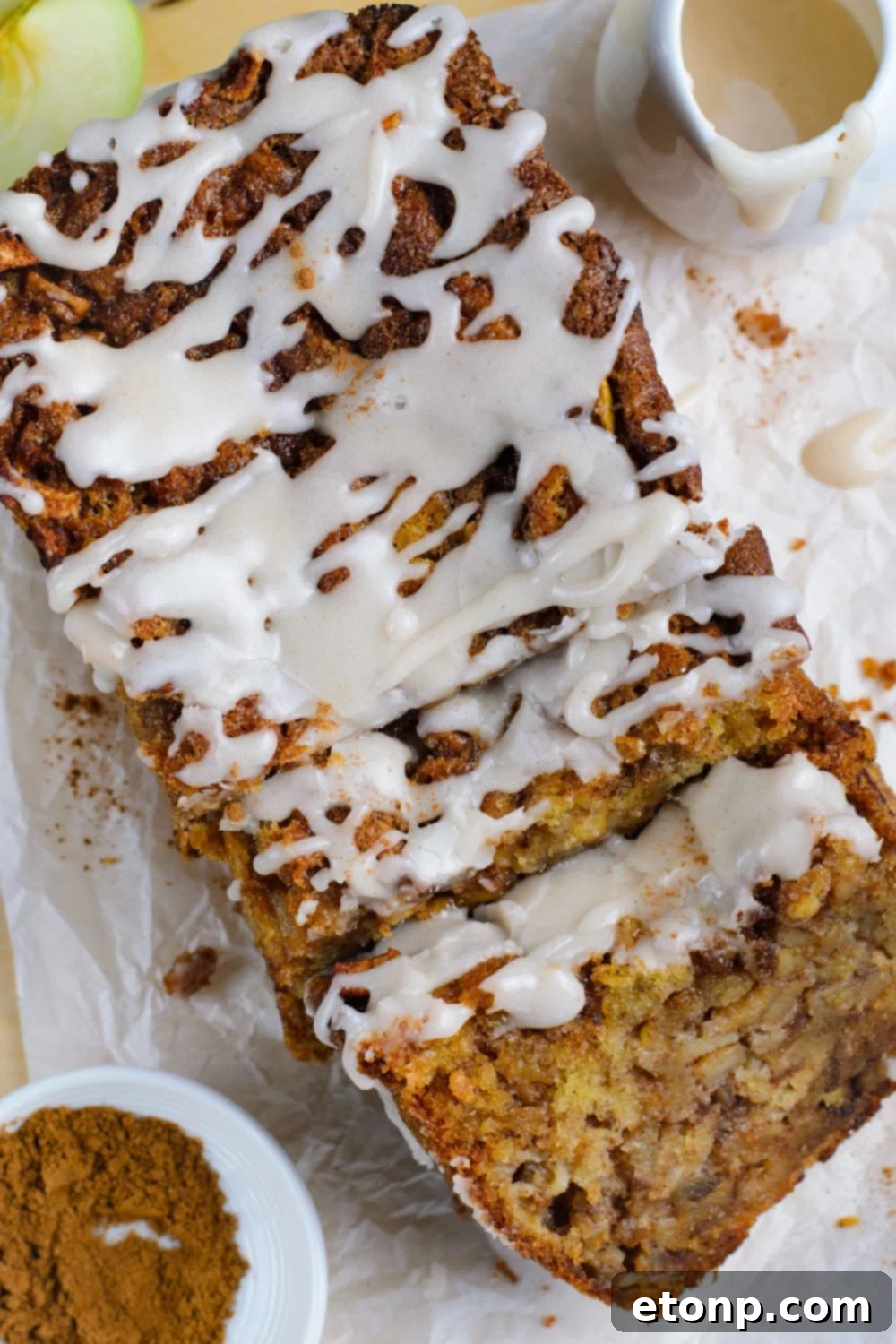 Amish Apple Fritter Bread sliced and laid out on table with a bowl of cinnamon sugar mixture to side