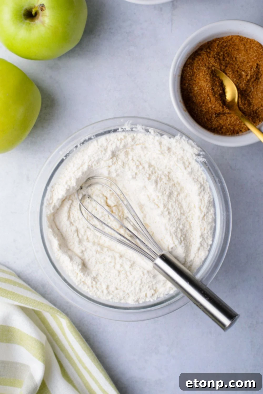 dry ingredients in a bowl for making amish bread and a bowl of cinnamon sugar mixture to side in another bowl