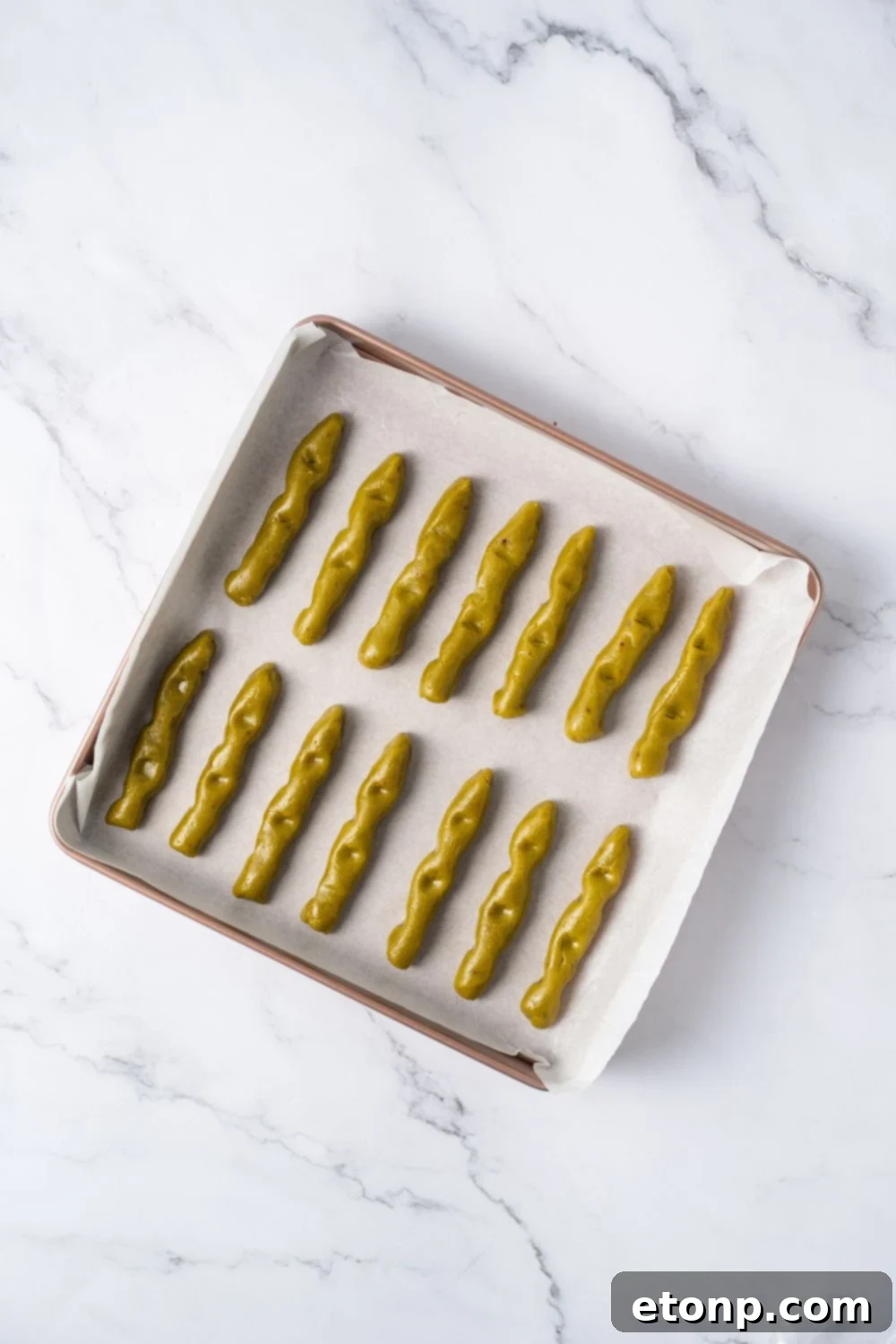 Witch Finger Cookie dough in strips on a baking dish with parchment paper 