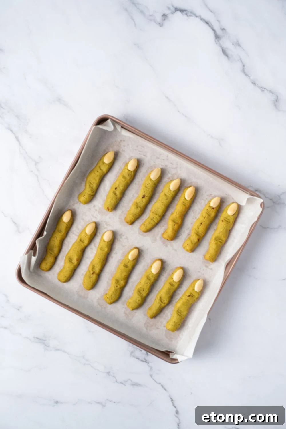 baked Witch Finger Cookies on a baking sheet with parchment paper on the table 