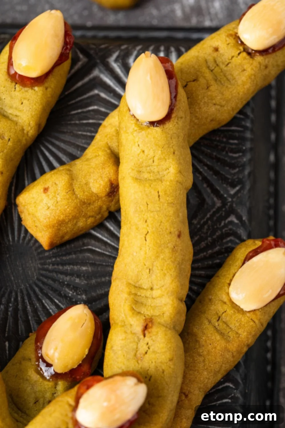 Witch Finger Cookies on a black tray with a close up of fingers 