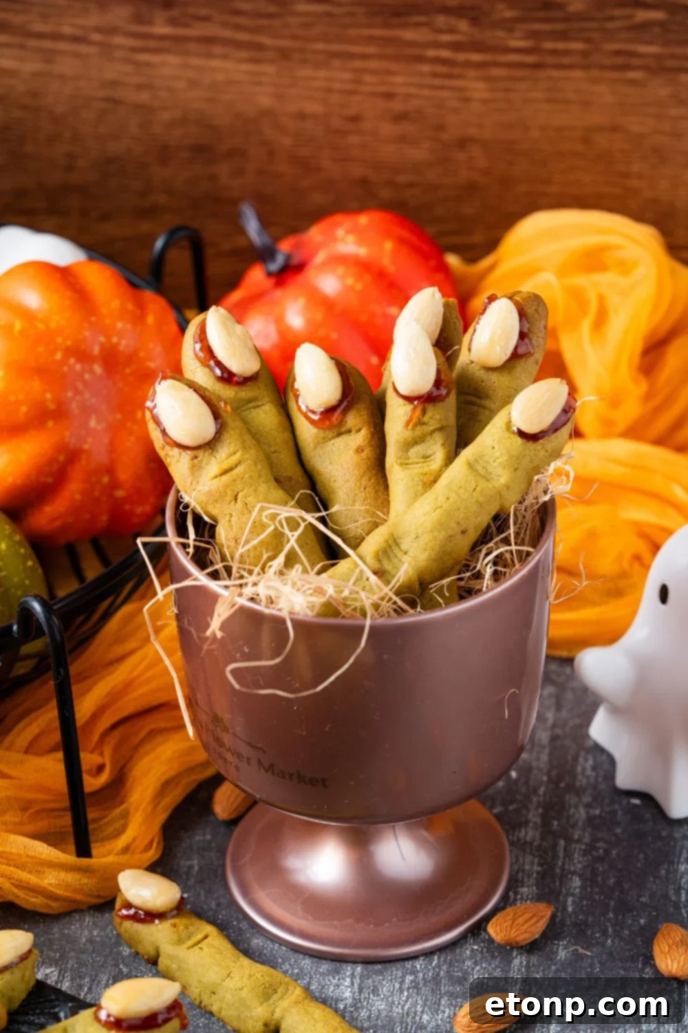 Witch Finger Cookies in a metal container in the center of a table that is decorated for Halloween 