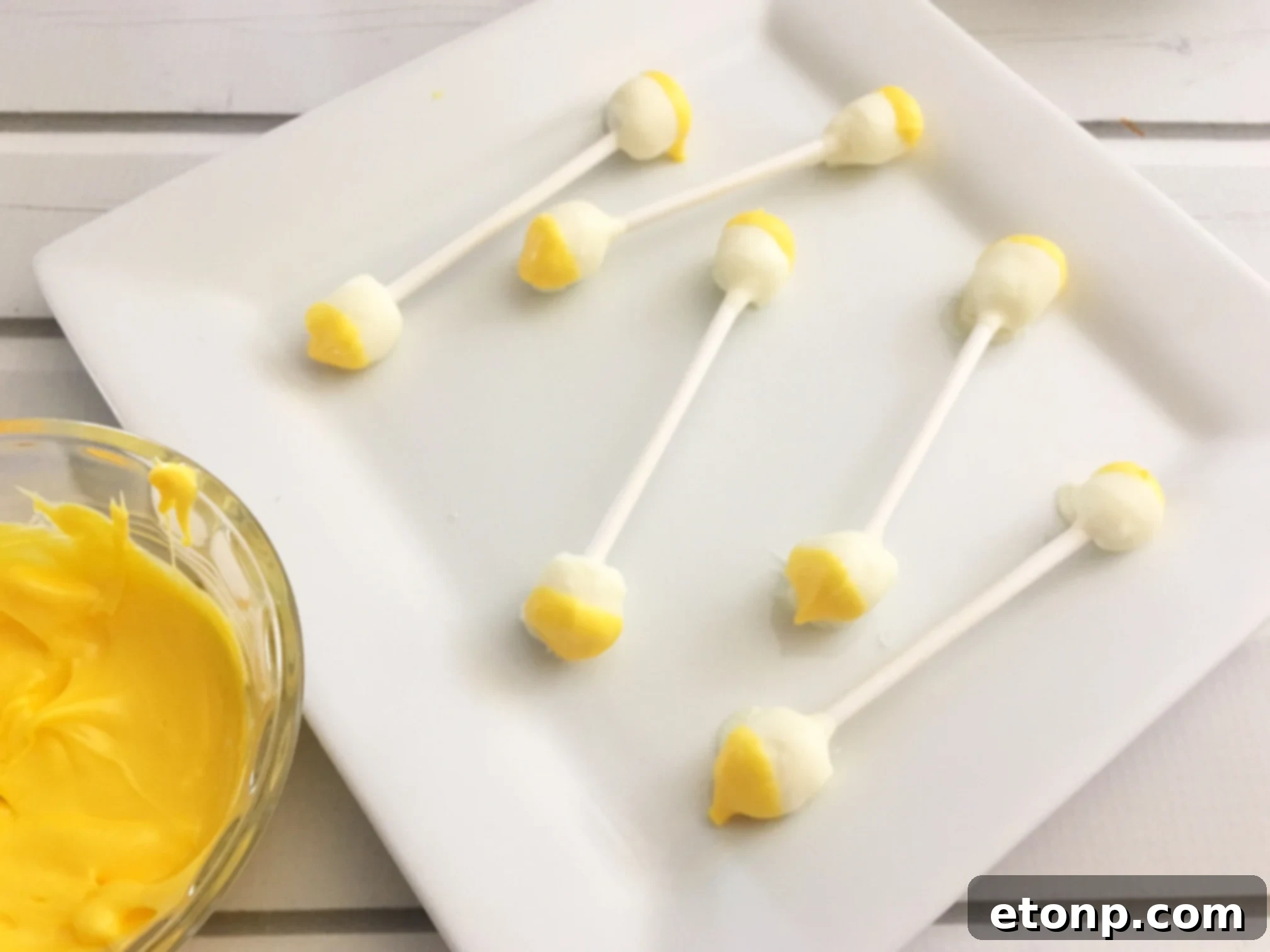 Hand holding a 'dirty Q-tip' Halloween treat, showing the detailing of the marshmallow and candy melts.
