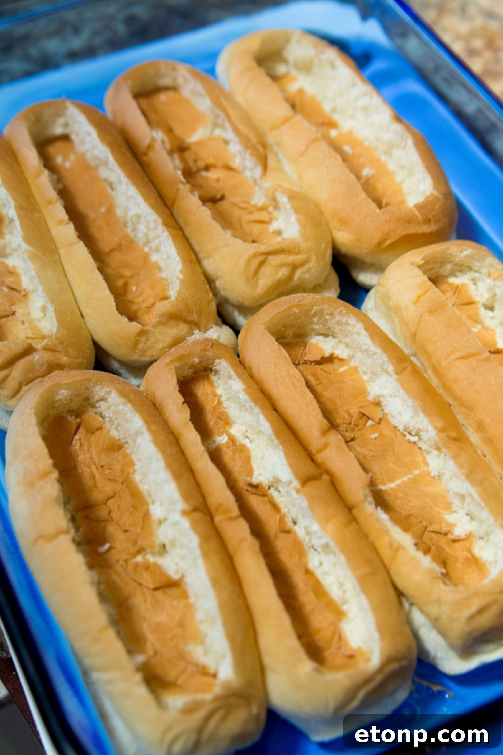 Loaded Chili Cheese Dog Boats 4 Hot dog buns arranged in a baking dish, ready for the next step of the recipe.