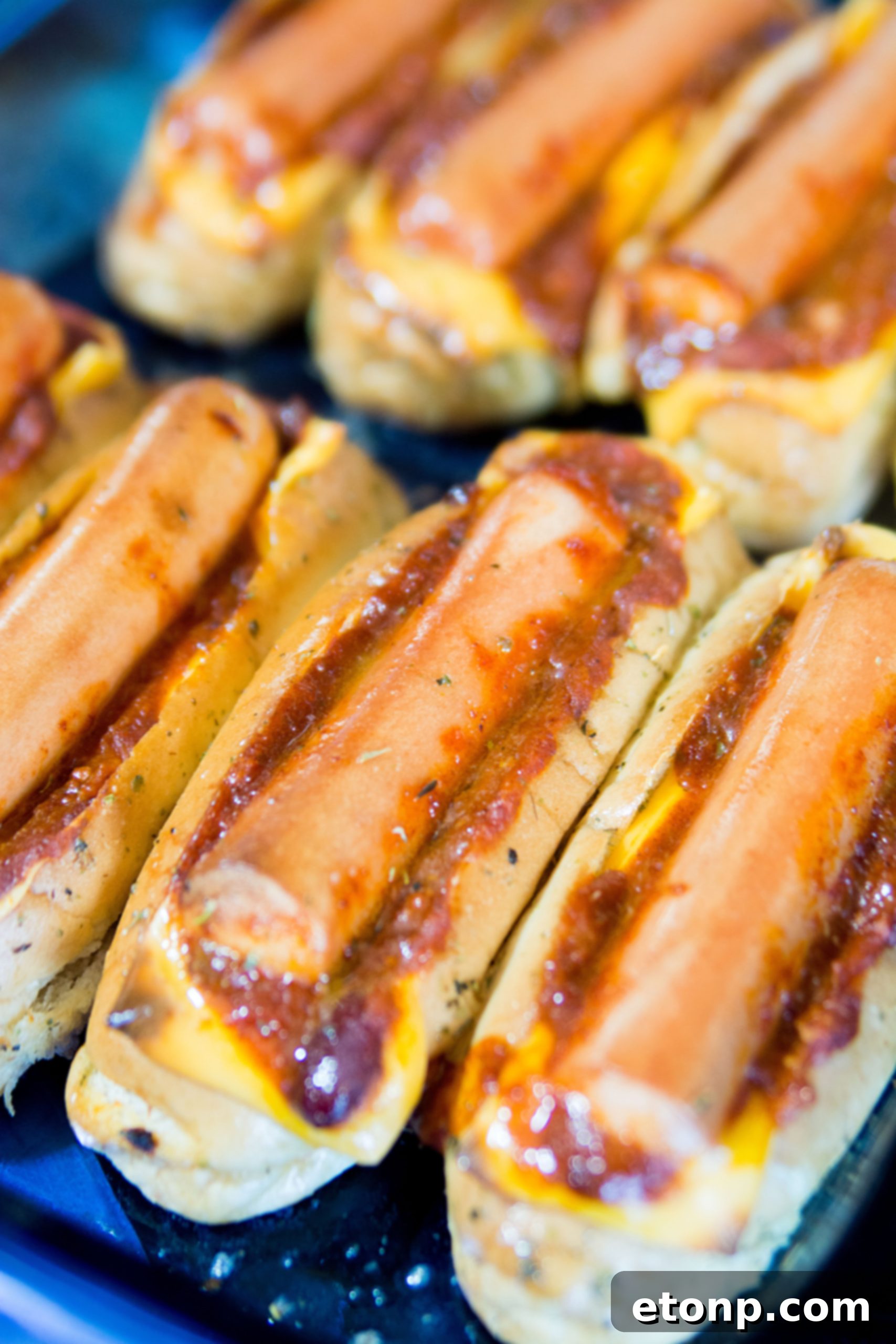 Loaded Chili Cheese Dog Boats 8 Stuffing hot dog buns with slices of cheddar cheese and chili, preparing for hot dogs.