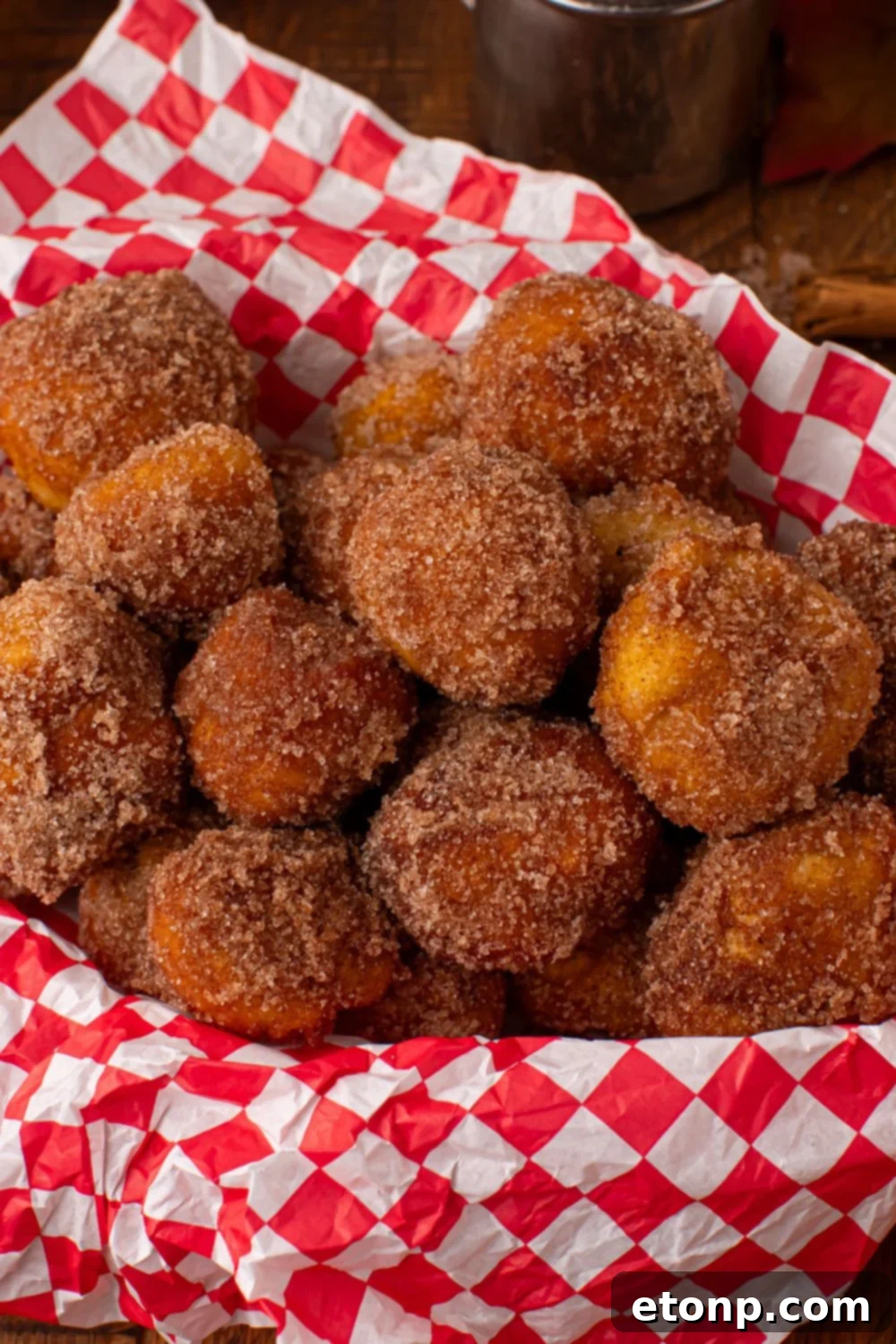 basket with a red checkered liner inside full of a bunch of Apple Pie Donut Holes 
