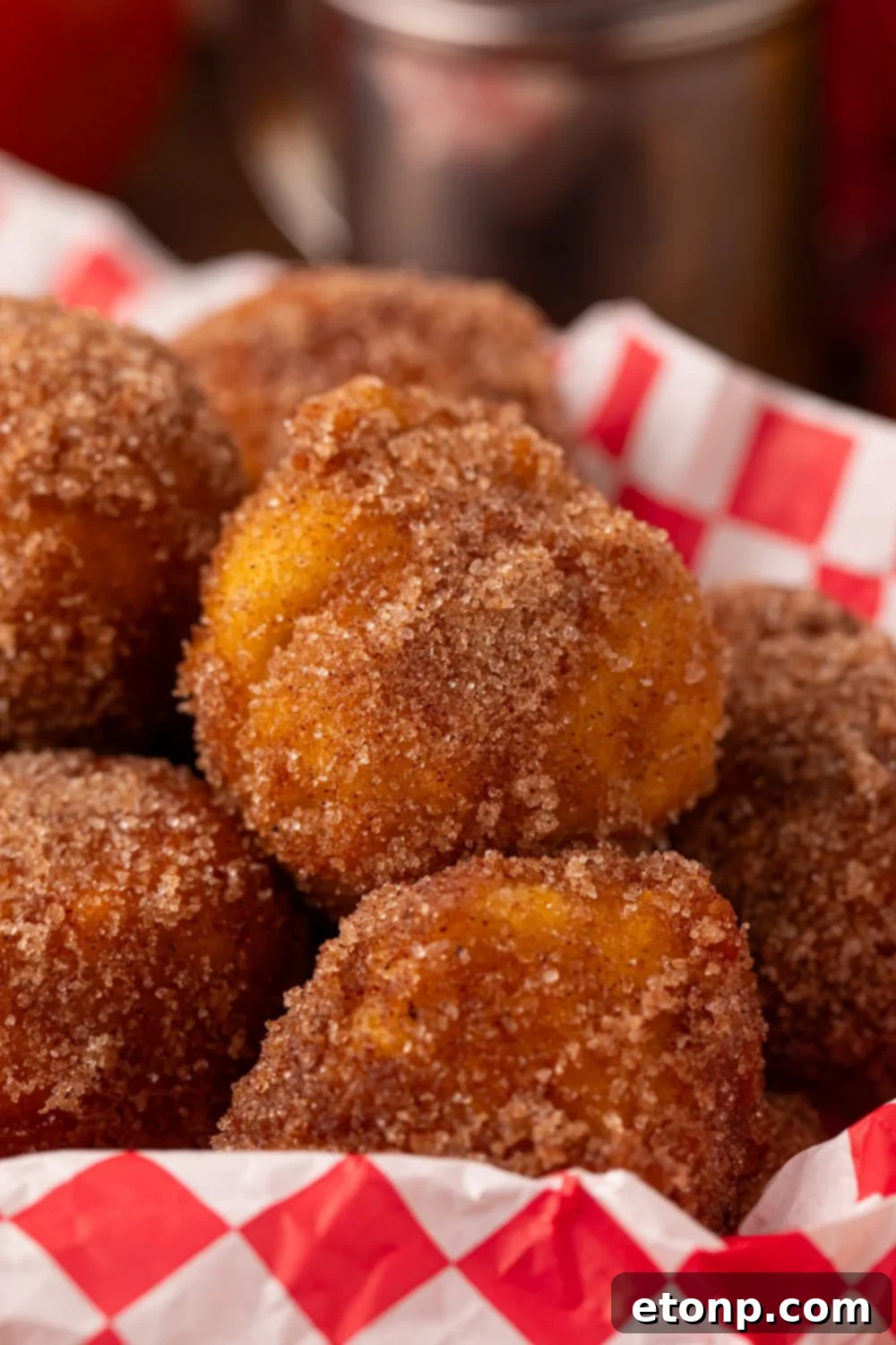 close up look of Apple Pie Donut Holes in a basket sitting on a table 