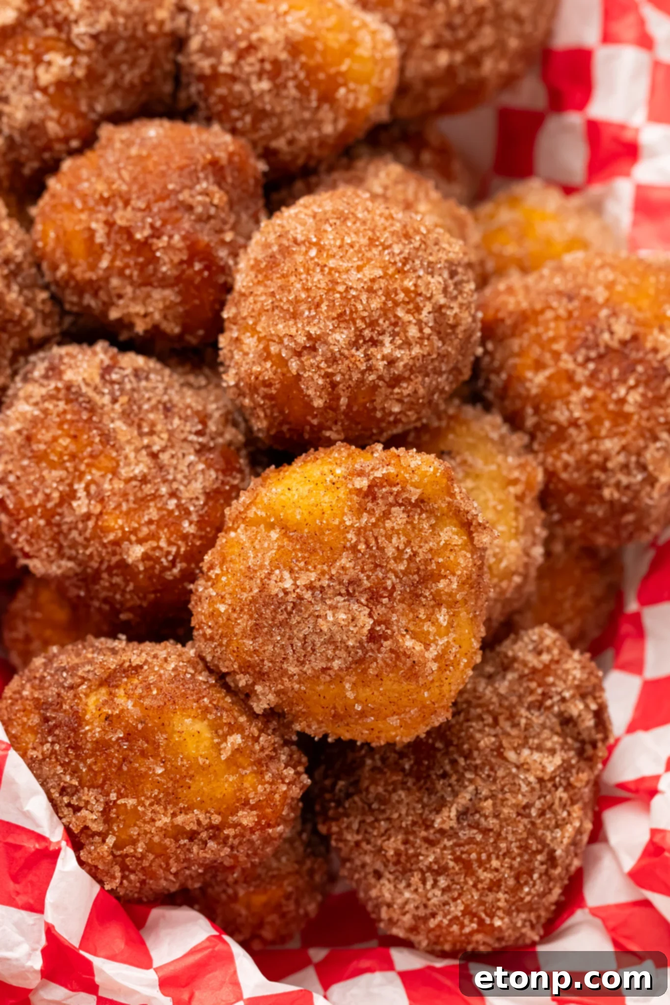 Apple Pie Donut Holes in a basket with a checked parchment paper in basket