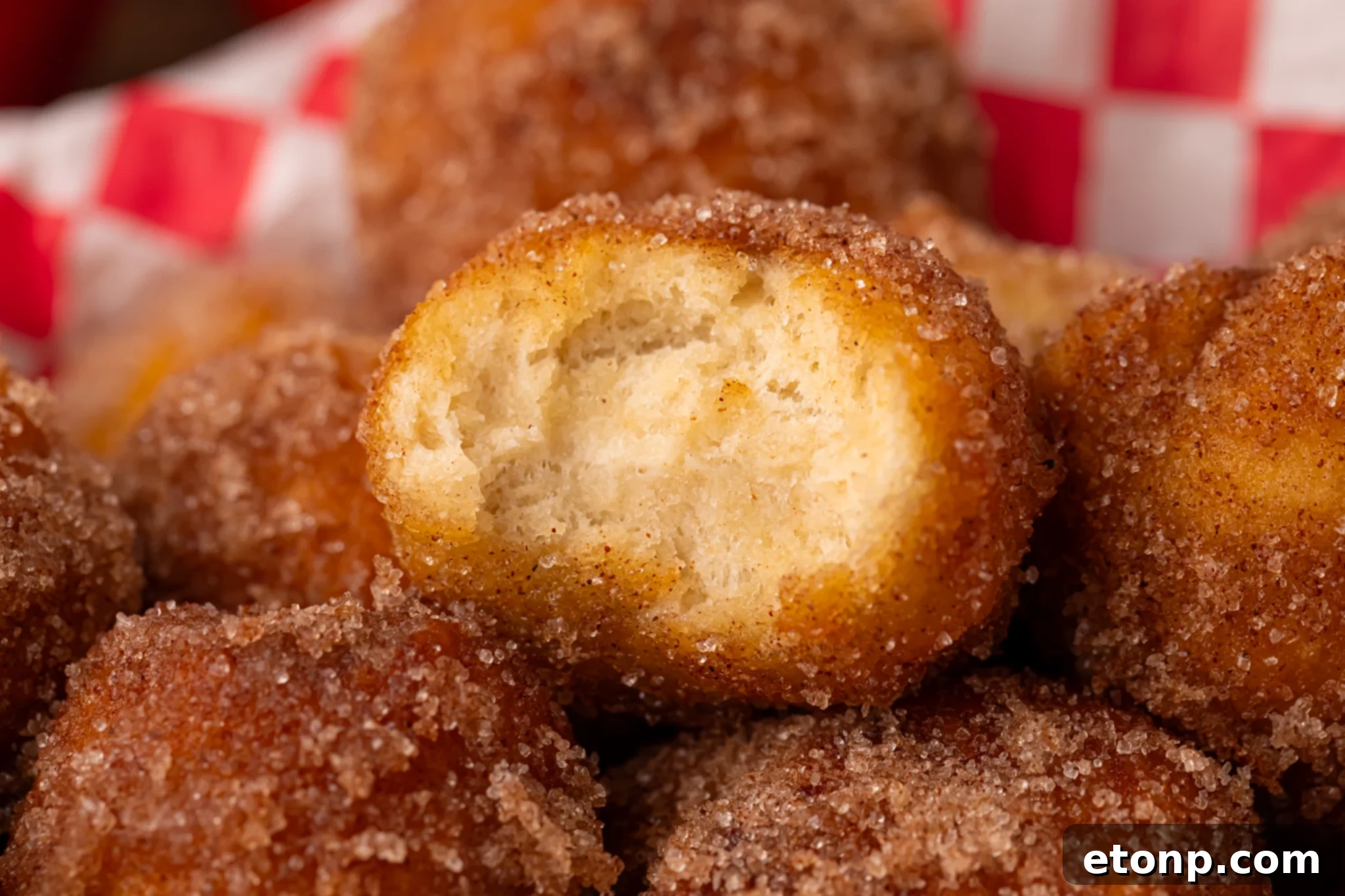 Apple Pie Donut Holes piled in a platter with a bite missing from the top one 