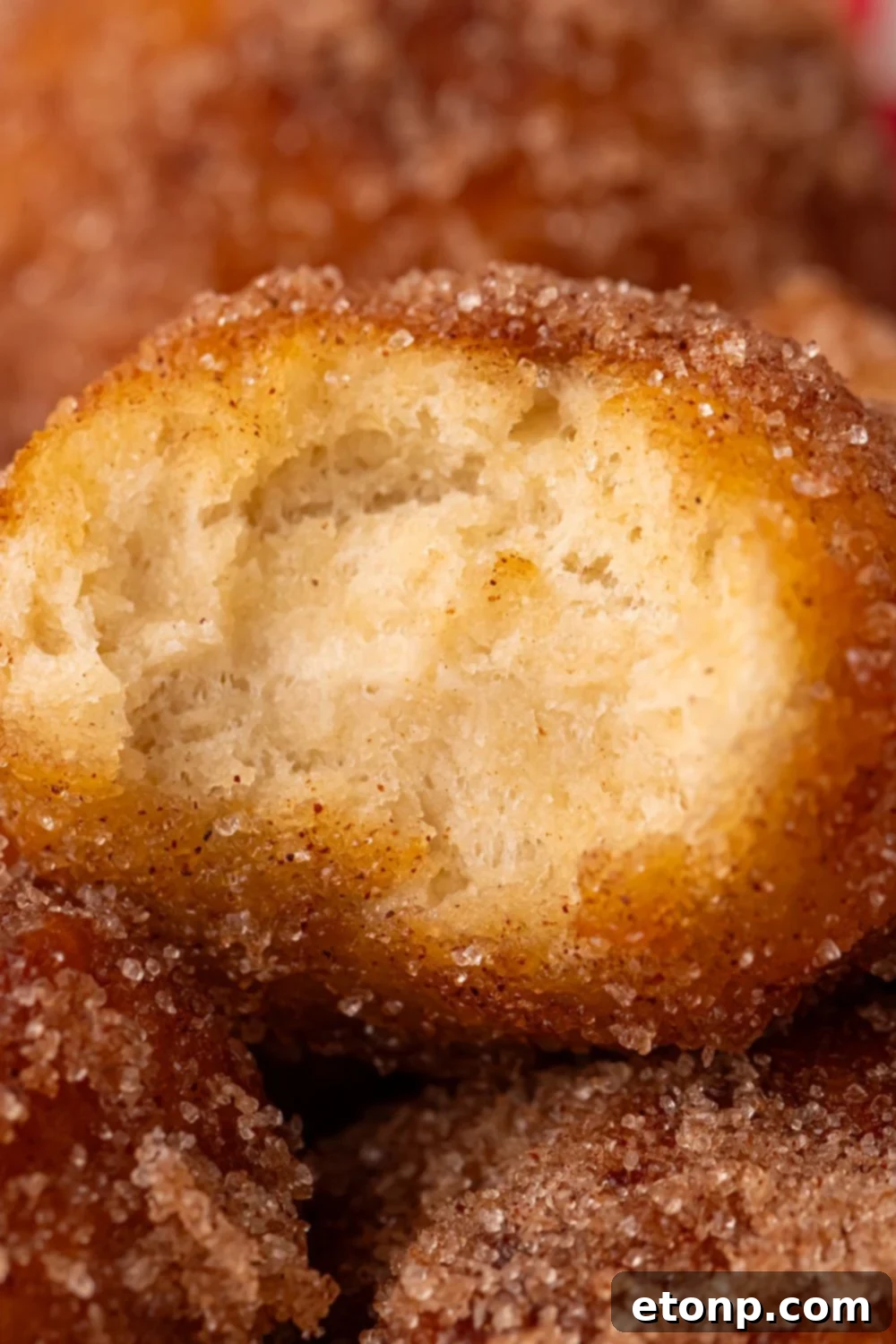 bite taken out of an apple donut hole stacked up on more donut holes