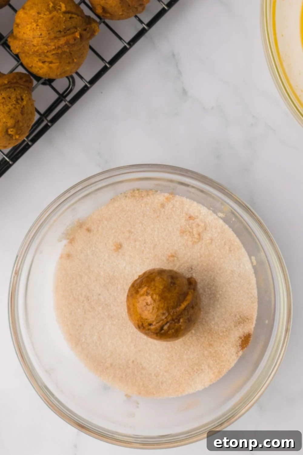 Pumpkin Spice Donut Hole in a glass bowl with cinnamon sugar mixture 