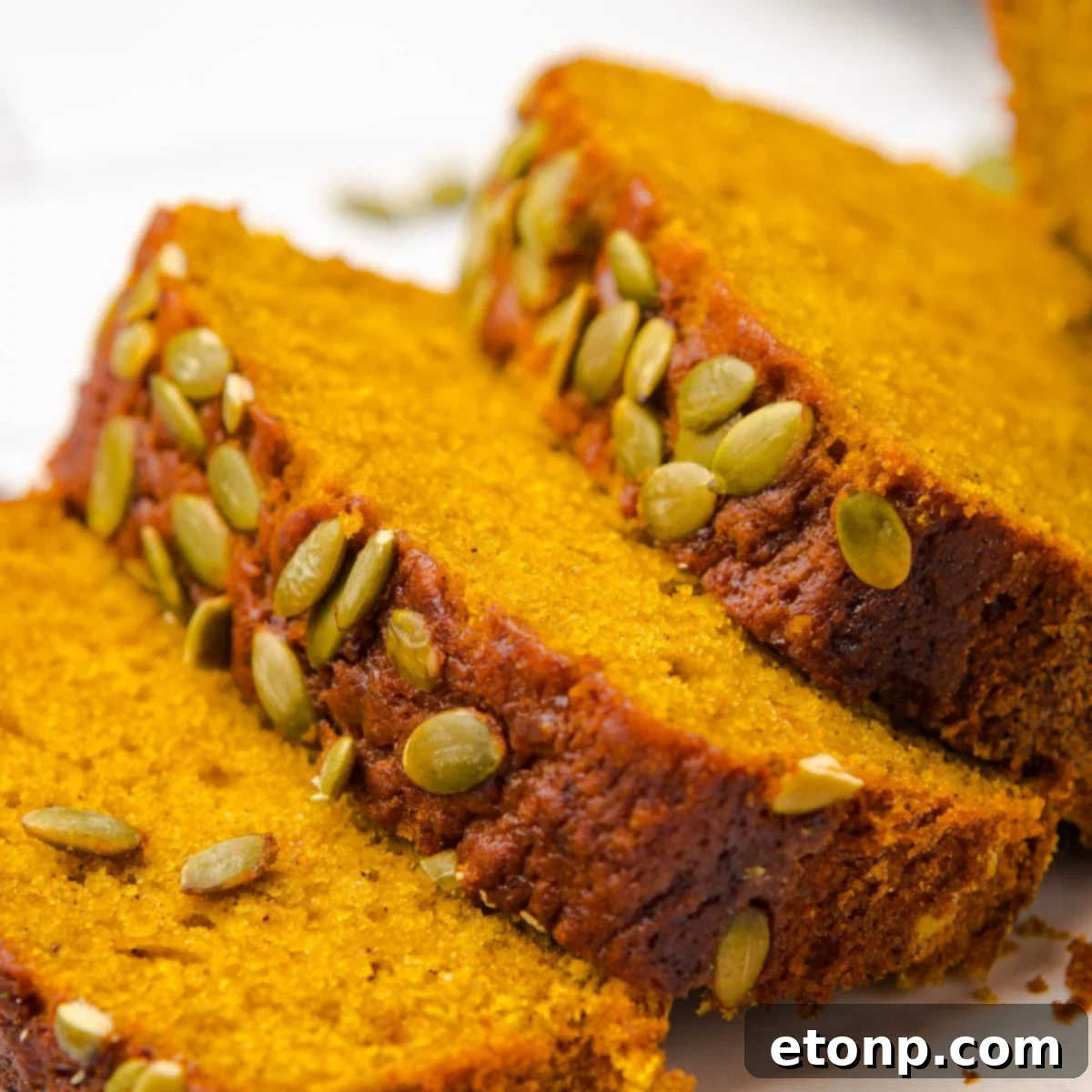 Starbucks Pumpkin Bread   sliced and placed on table with pumpkin seeds on top of each loaf 