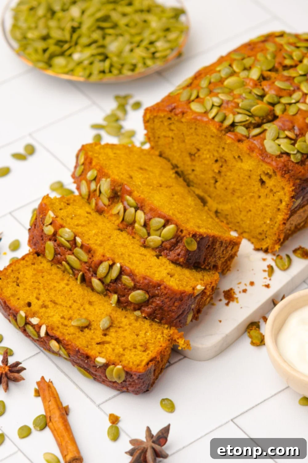 Starbucks Pumpkin Bread on a cutting board, and part of the loaf is sliced into thick slices and laid out on the table 