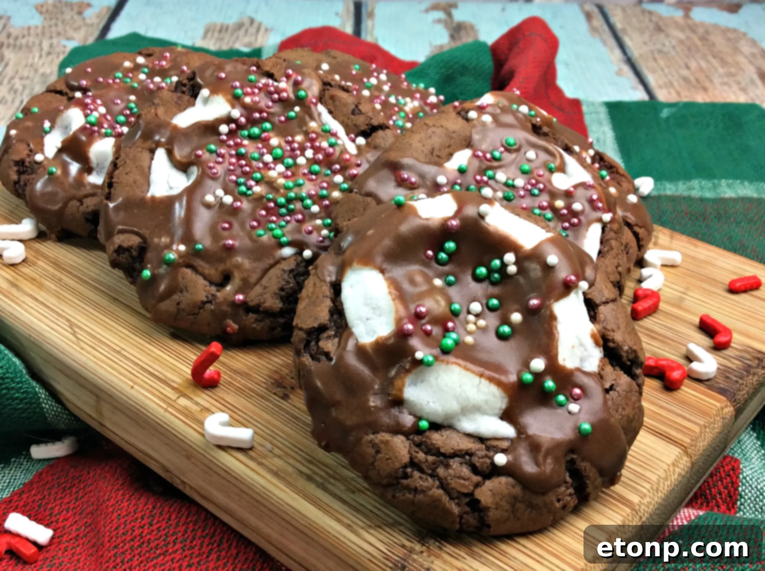 A tray of beautifully iced and sprinkled hot cocoa marshmallow cookies, showcasing their holiday readiness for a festive gathering.