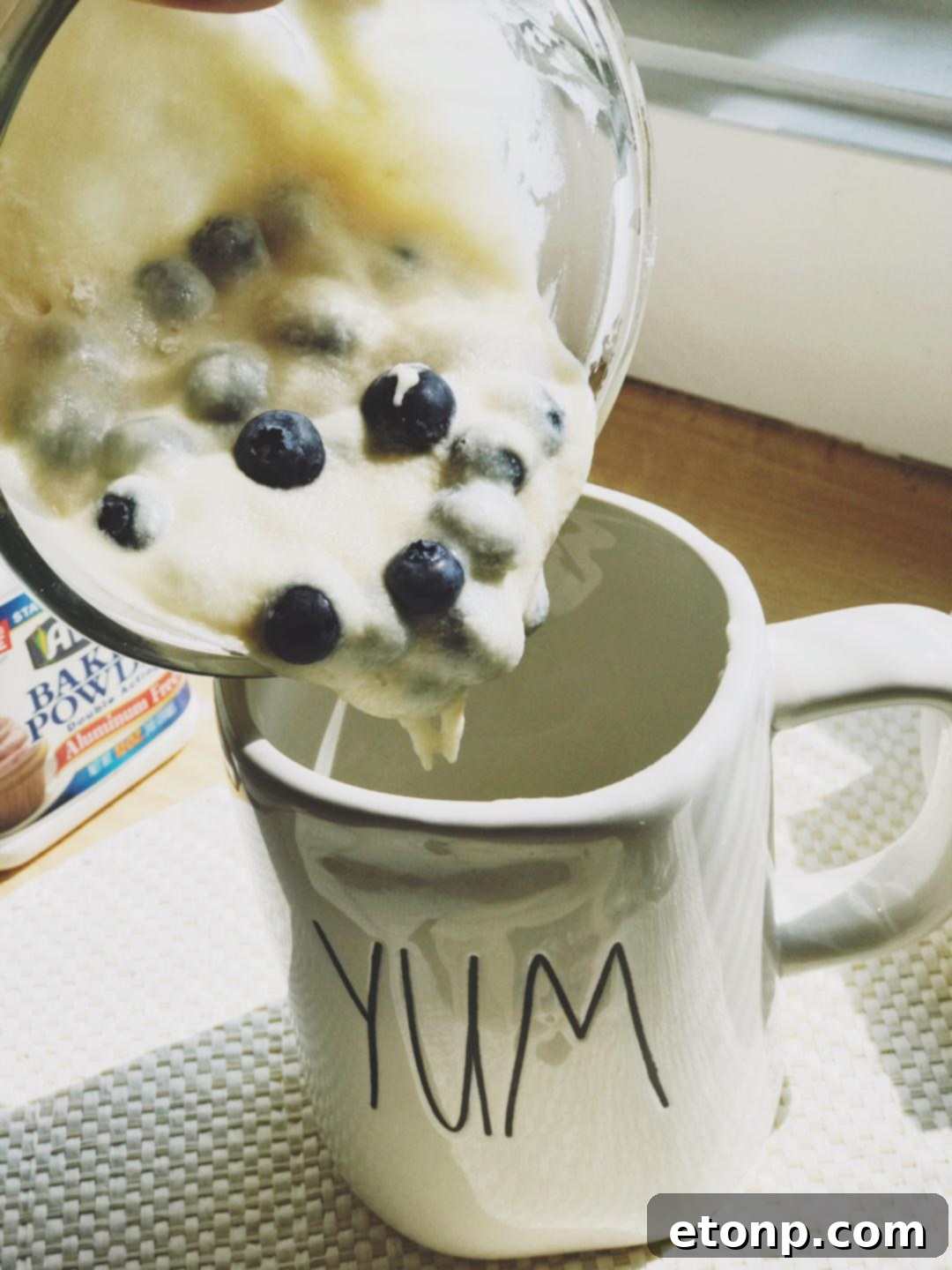 Mug cake batter with blueberries in a microwave-safe mug