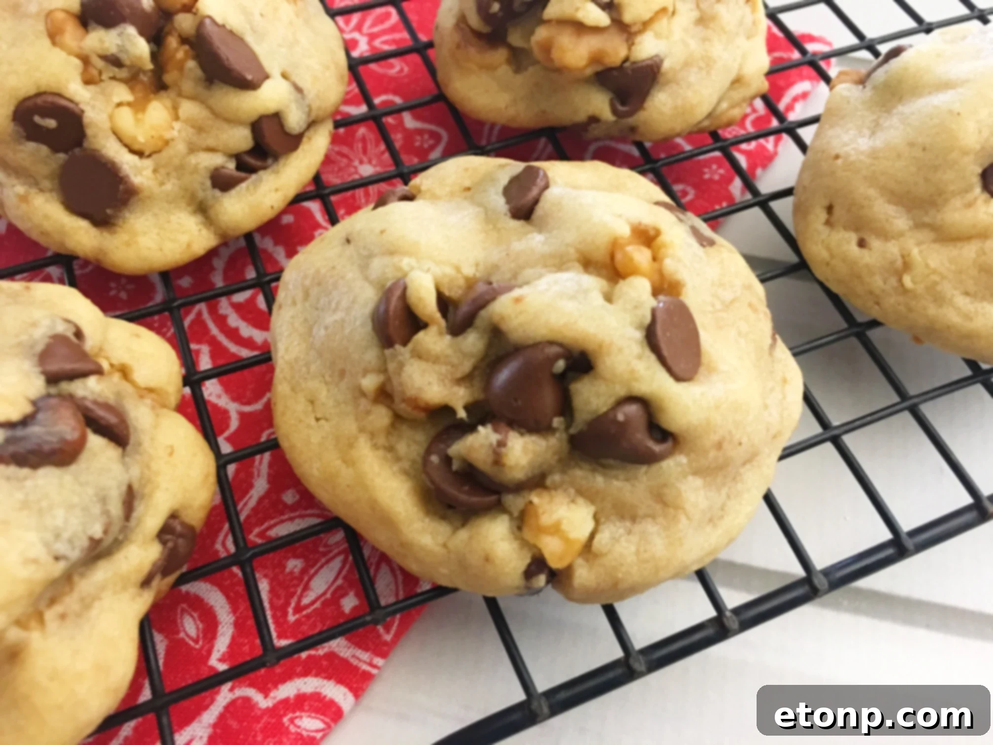 Stack of soft chocolate chip cookies next to a cold glass of milk
