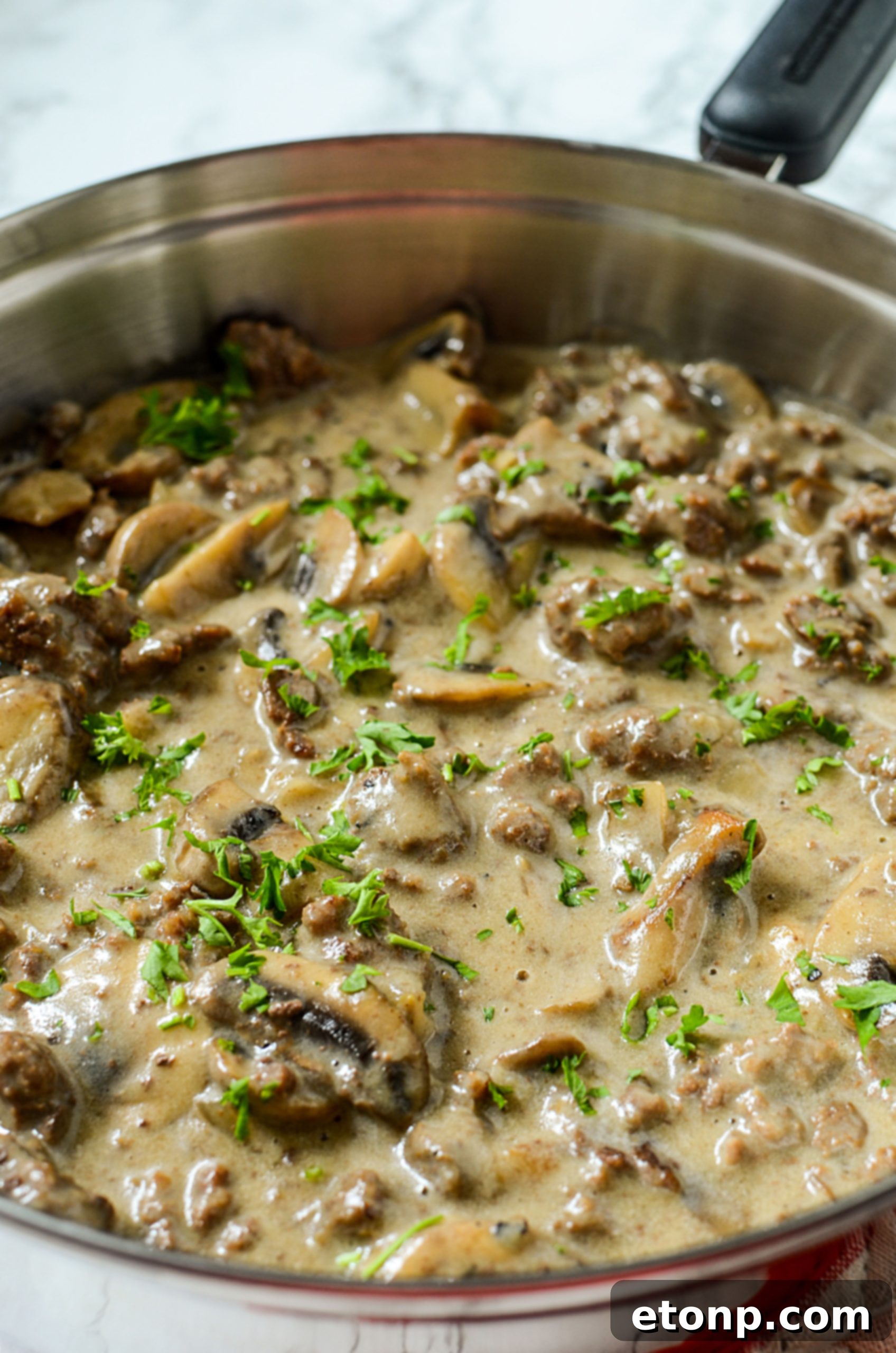 Close-up of ground beef stroganoff with a dollop of sour cream.
