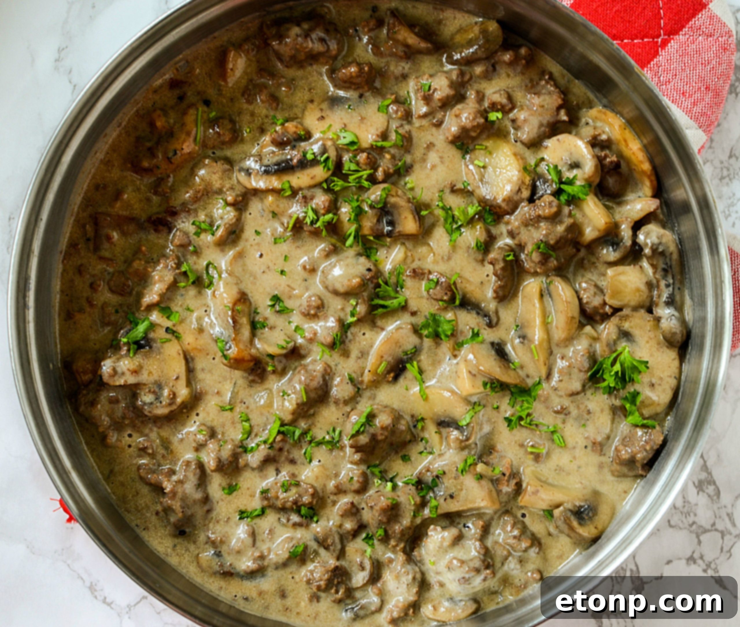 Overhead shot of the completed ground beef stroganoff, garnished with parsley.