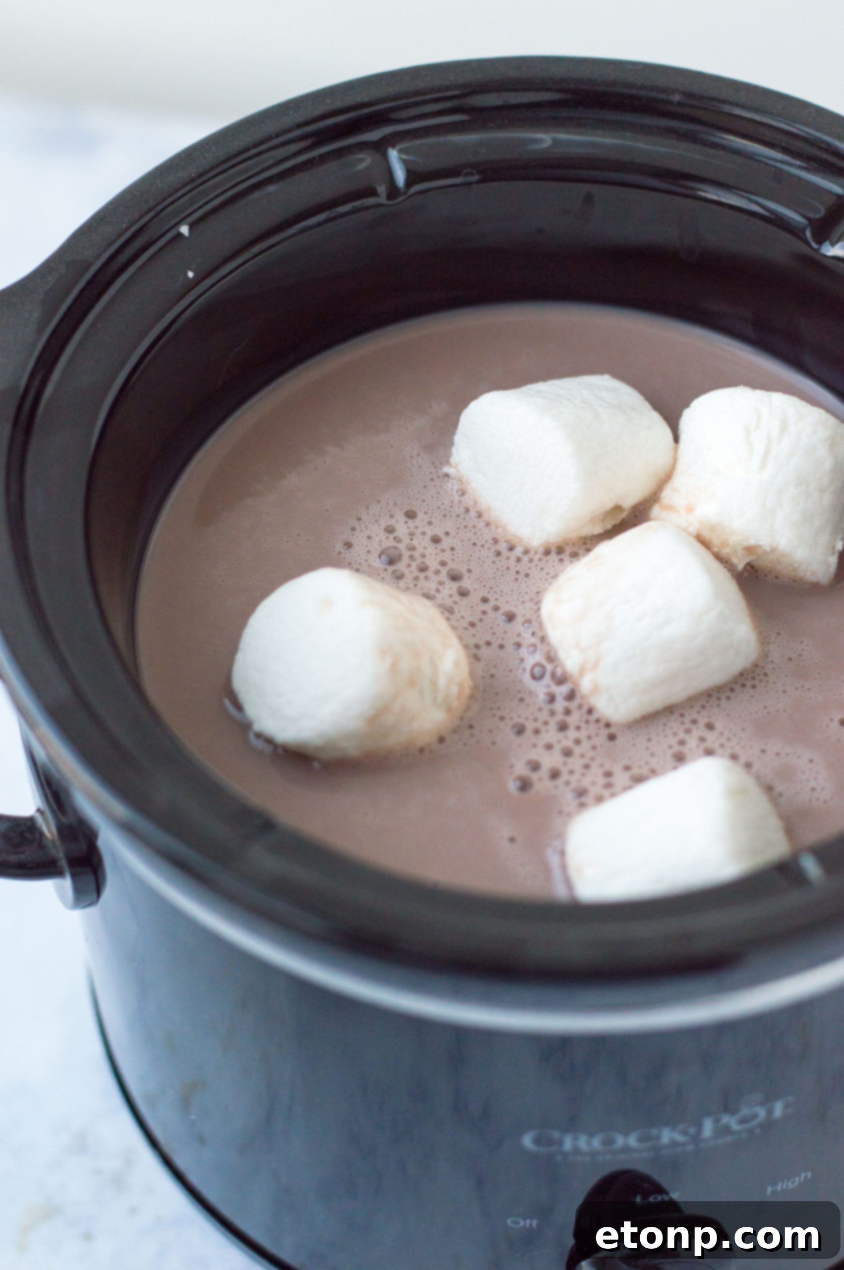 Delicious slow cooker hot chocolate bubbling away in a crock-pot, ready to serve.