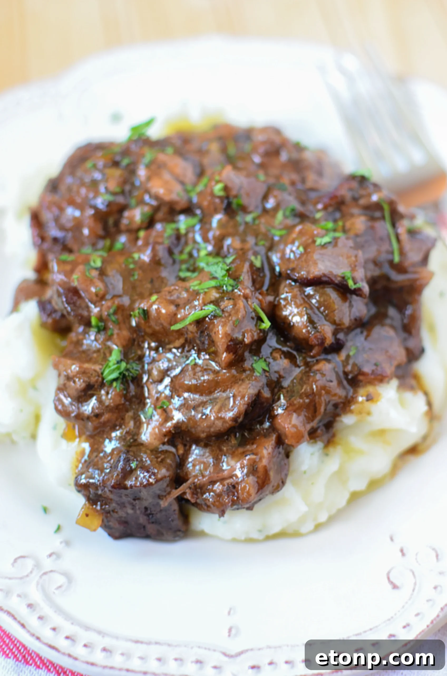 Final plated dish of slow cooker beef tips with gravy and potatoes