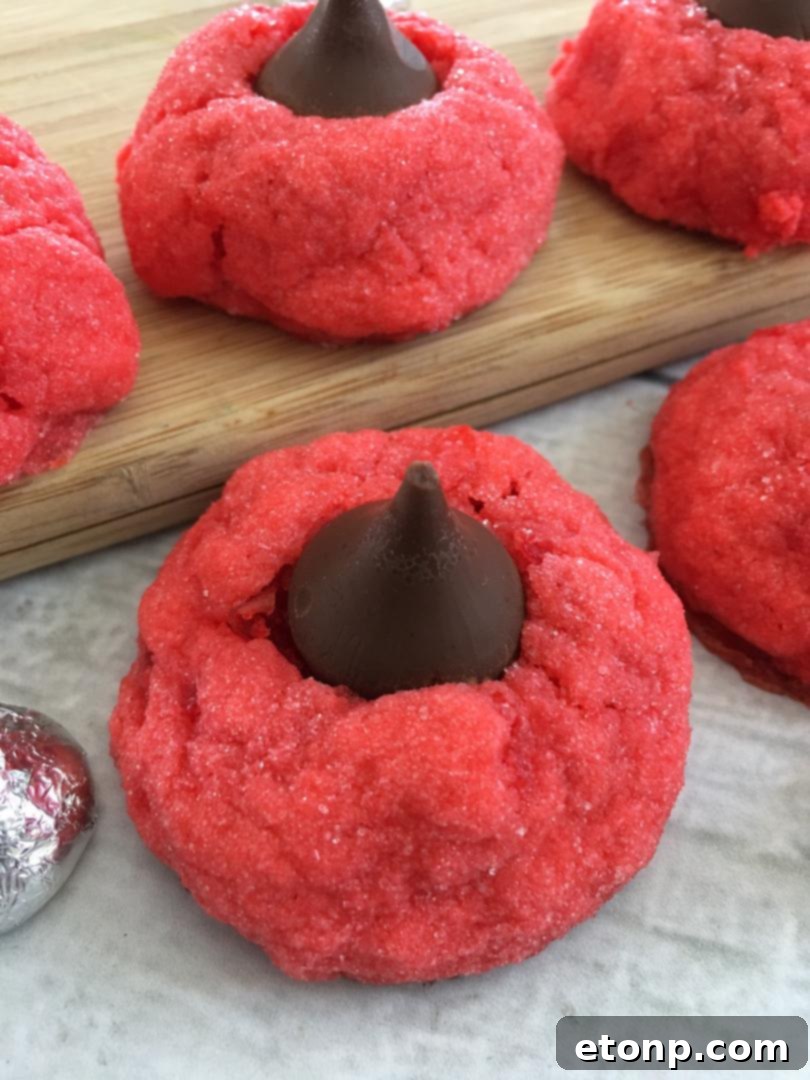 A stack of three Cherry Kiss Cookies on a white plate, highlighting their perfect form and the inviting chocolate center.