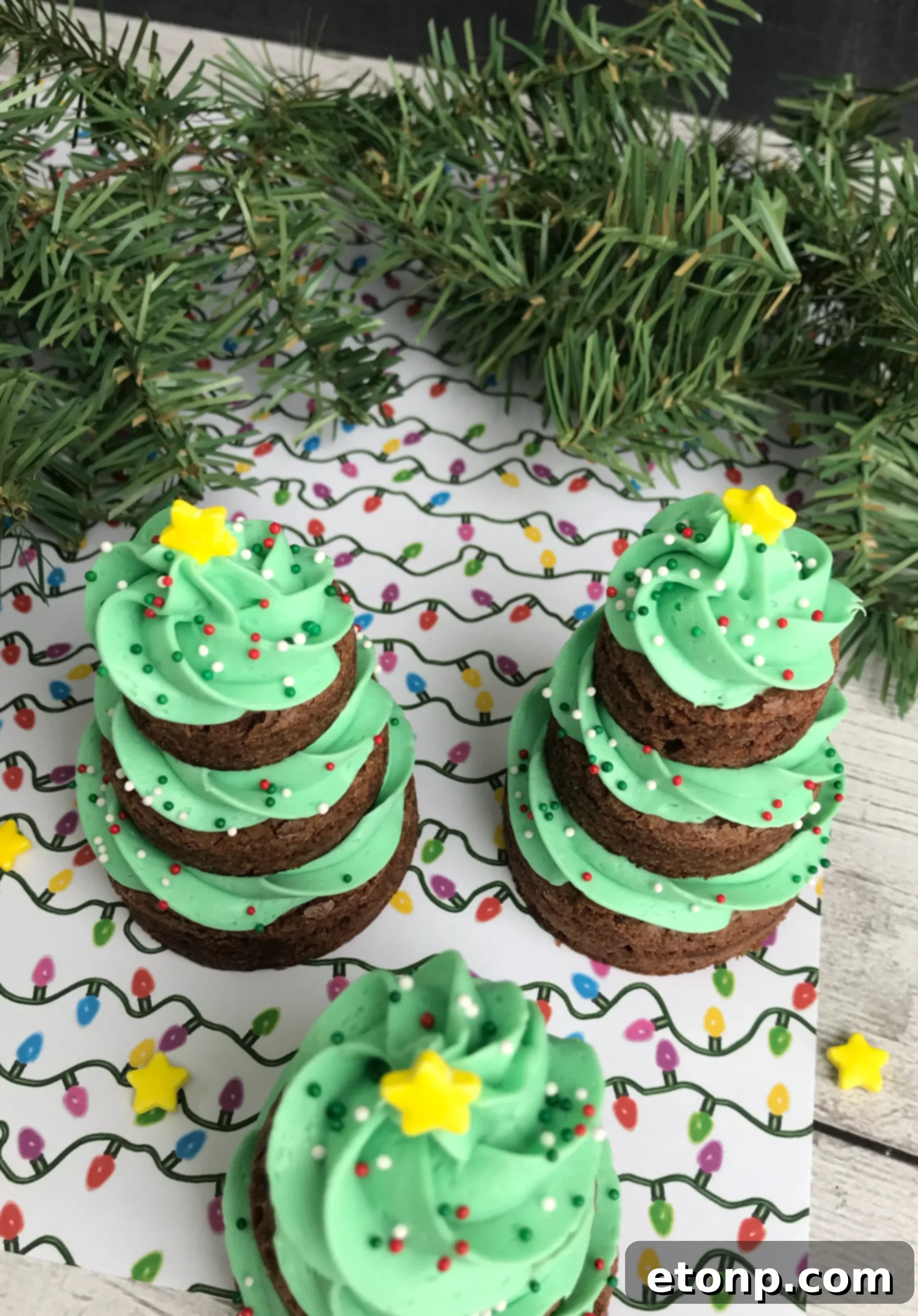 Christmas Tree Brownie Treats 4 Stacked brownie circles with green frosting forming the base of Christmas tree brownies