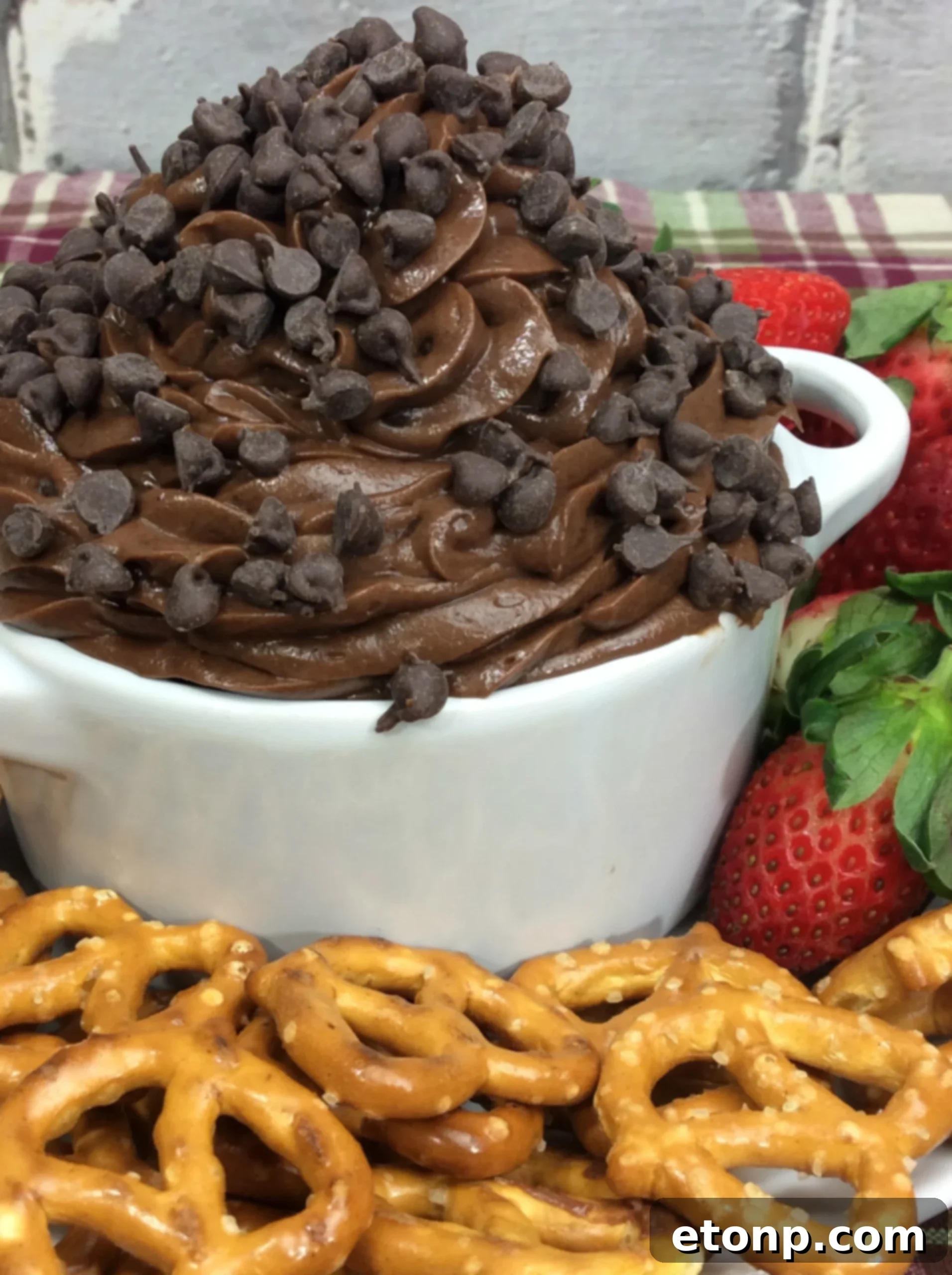 Irresistible Brownie Dip 2 Delicious Brownie Batter Dip in a white bowl, garnished with chocolate chips and a spoon, ready to be served