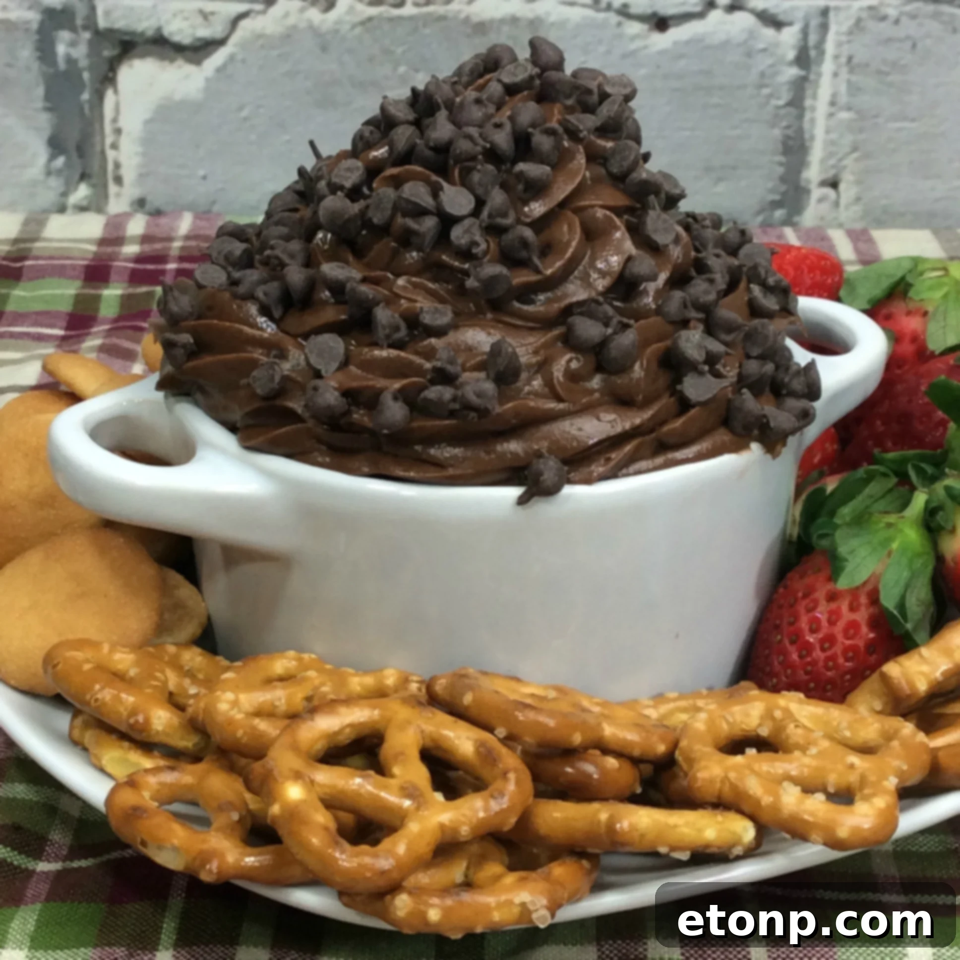 Irresistible Brownie Dip 3 Close-up shot of creamy Brownie Batter Dip, showing its smooth texture and scattered mini chocolate chips, with dippers in the background