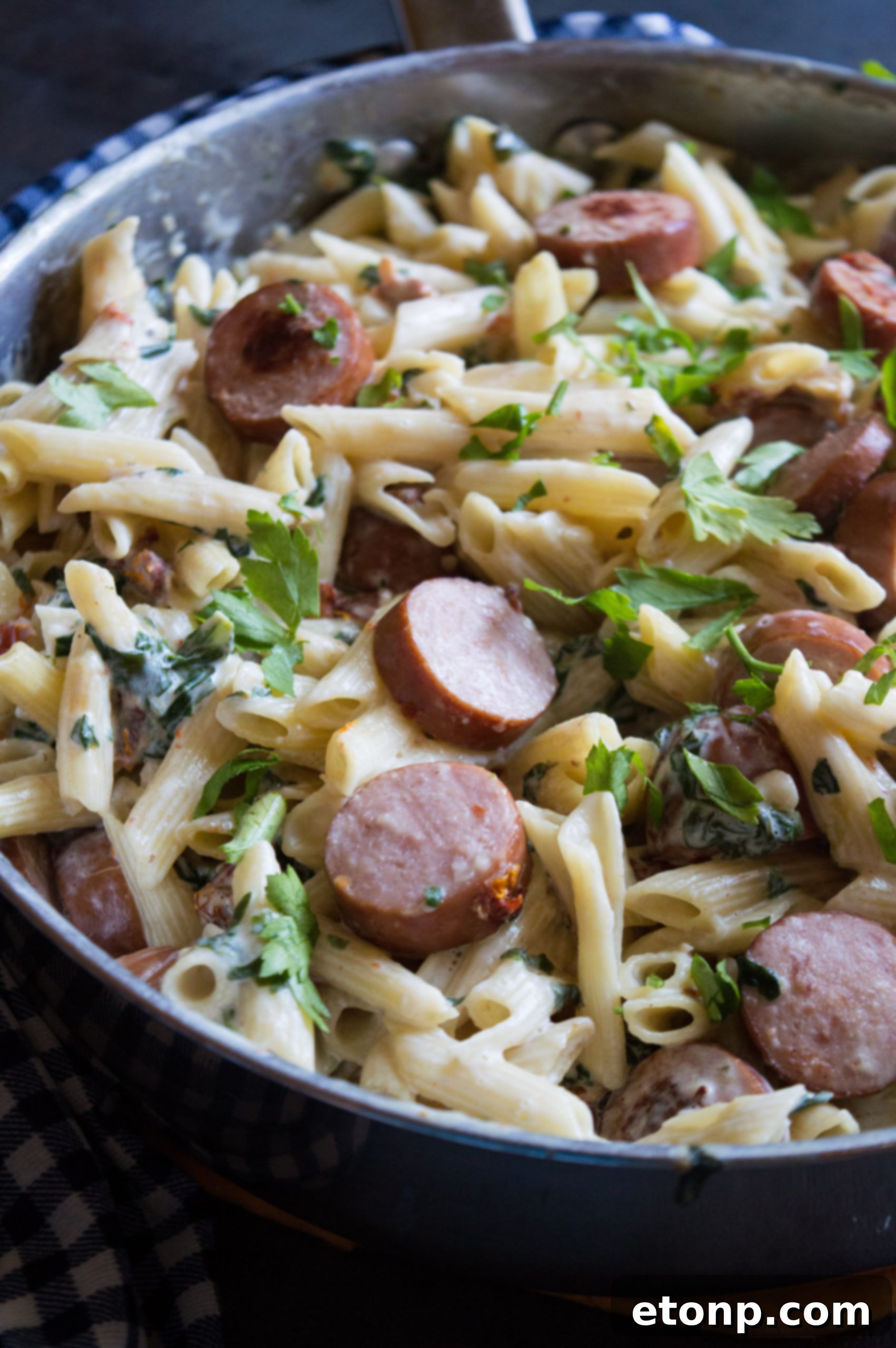 A close-up of a fork twirling a generous portion of creamy mozzarella pasta.