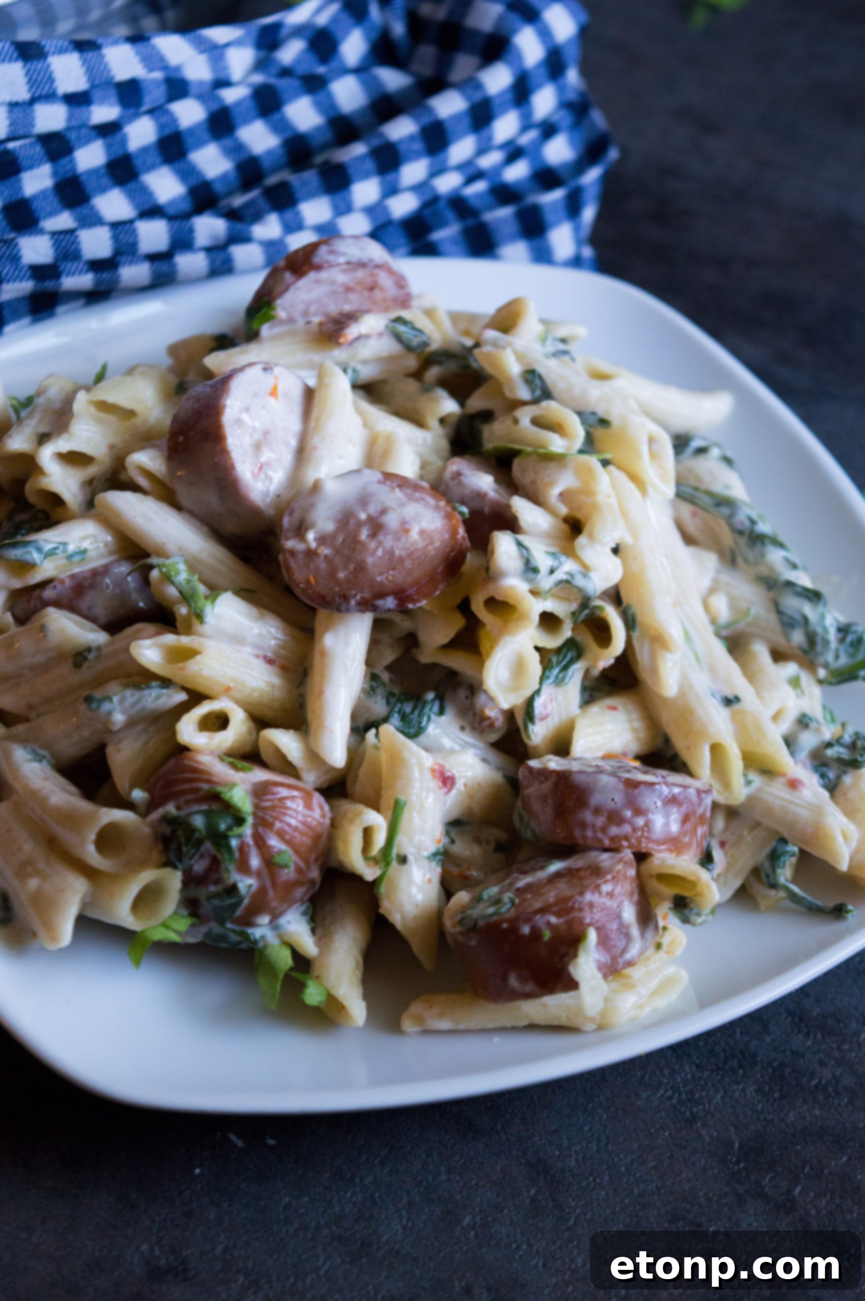 An overhead view of the pasta dish, highlighting the melted mozzarella and cooked sausage pieces.