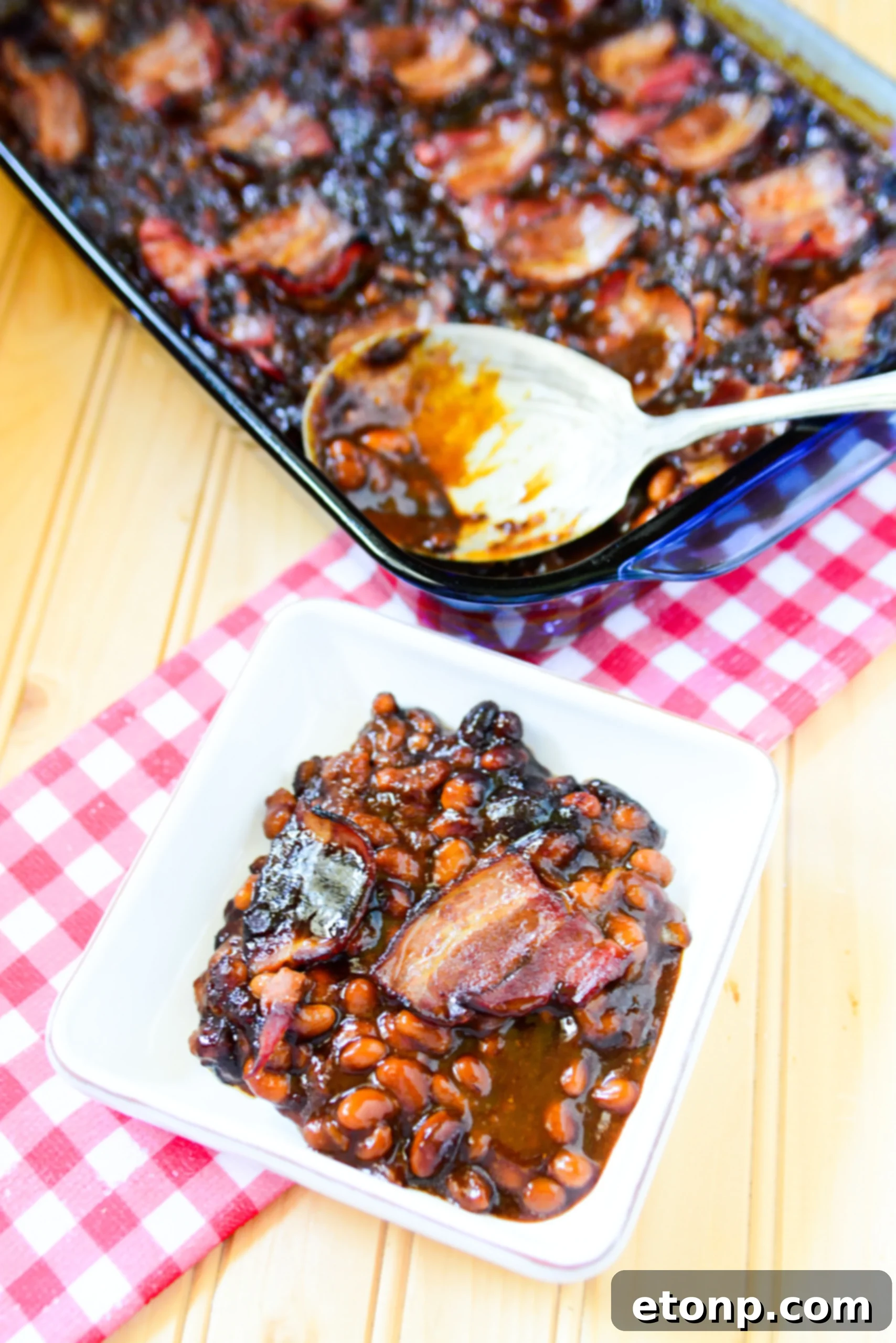 Ultimate Brown Sugar Bacon Baked Beans 6 The finished brown sugar bacon baked beans with a dark, caramelized top and crispy bacon