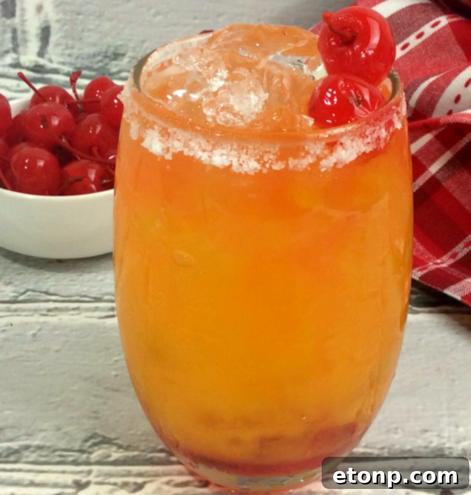 Refreshing Take Me on the Couch Cocktail in a glass with a vibrant orange hue, ideal for a girls' night.