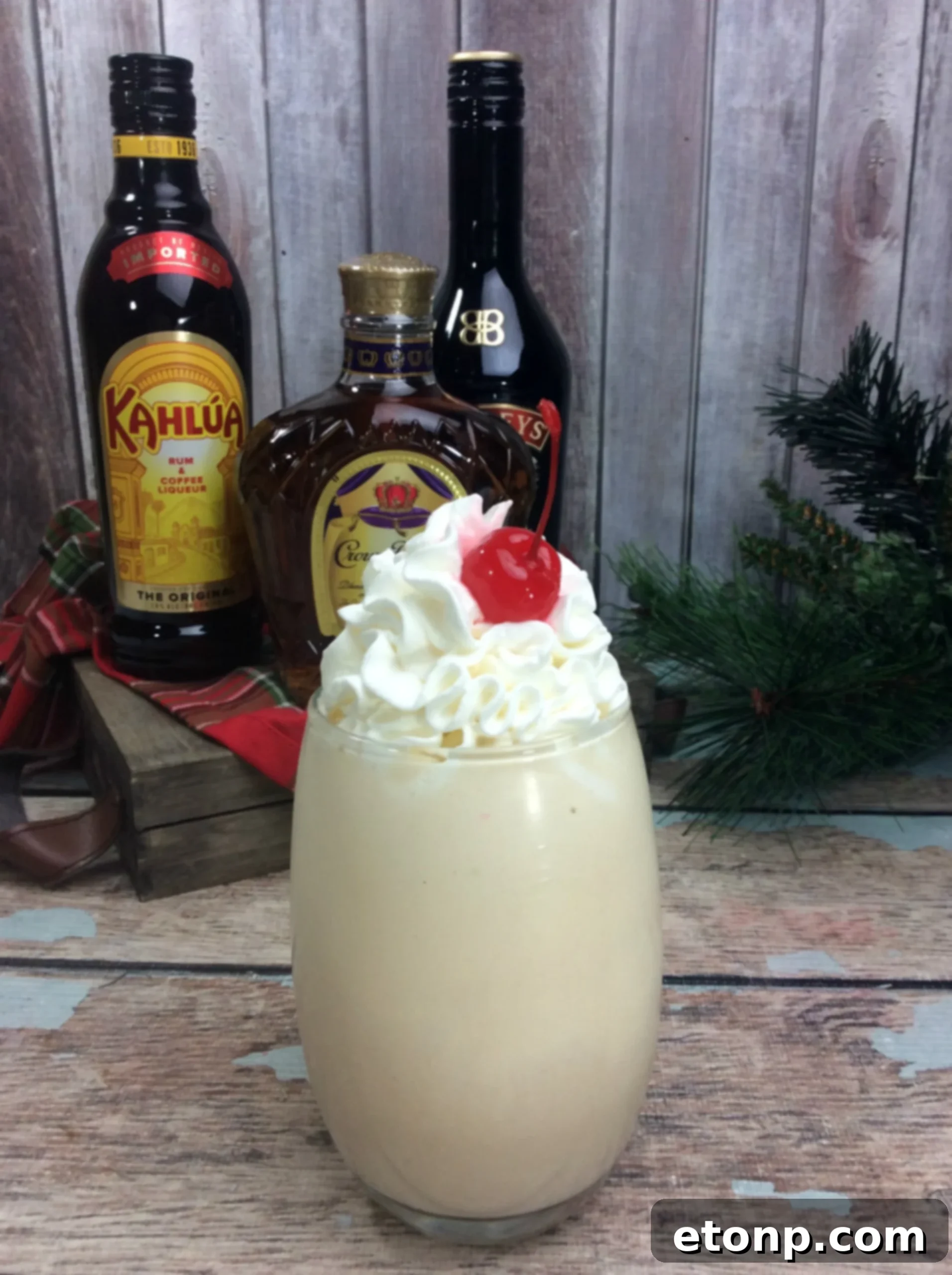 A trio of Alaska Duck Fart cocktails in glasses, garnished with whipped cream and cherries, ready to be served.