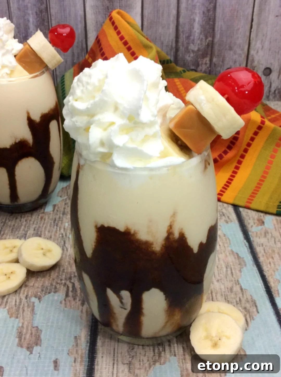 Chunky Monkey Cocktail in a tall glass, garnished with chocolate drizzle and a banana slice