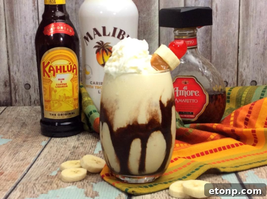 Chunky Monkey Cocktail in an elegant glass with whipped cream, cherry, and chocolate syrup drizzle