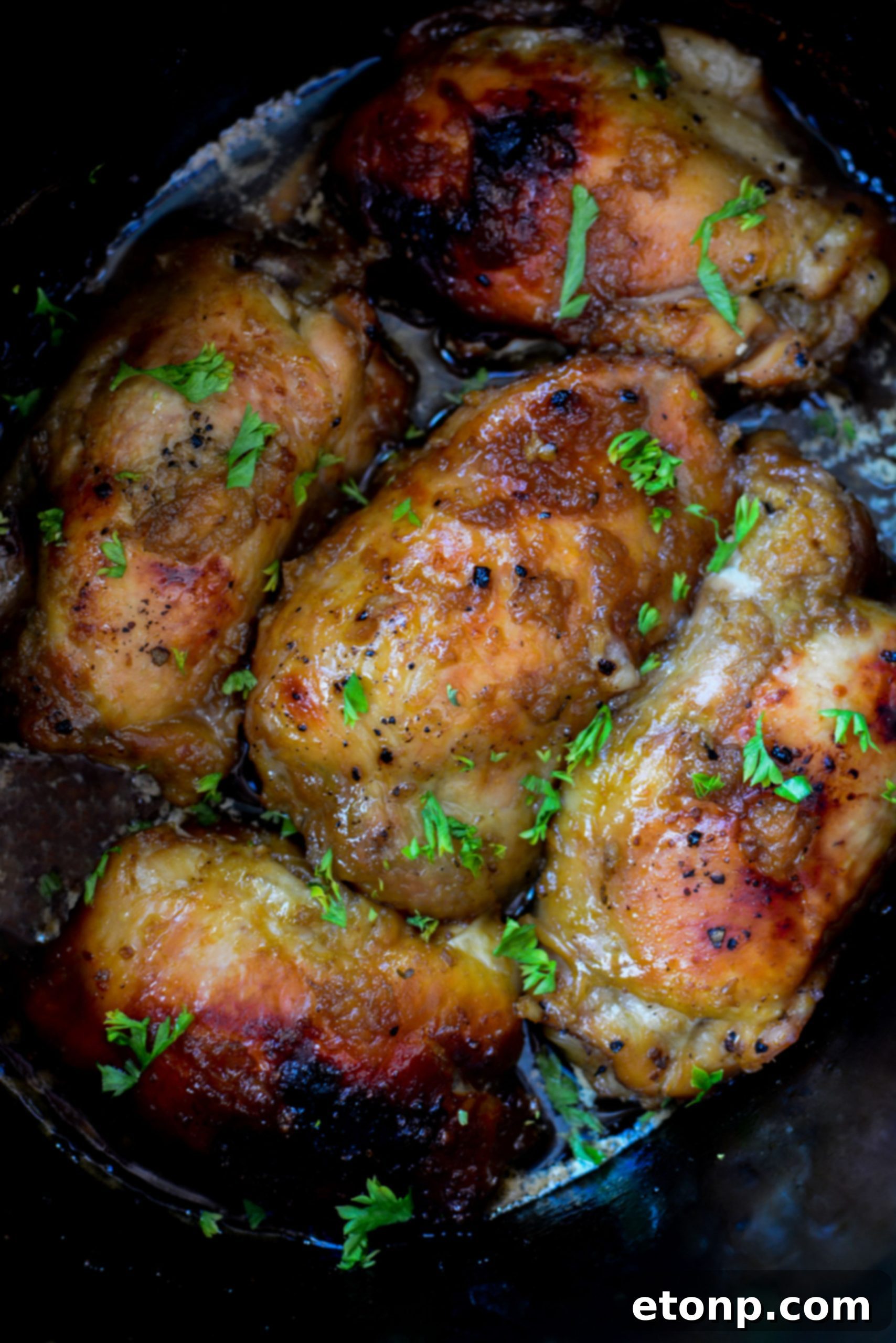 Close-up of golden brown slow-cooked chicken, perfectly broiled and ready to be served, highlighting its succulent texture.