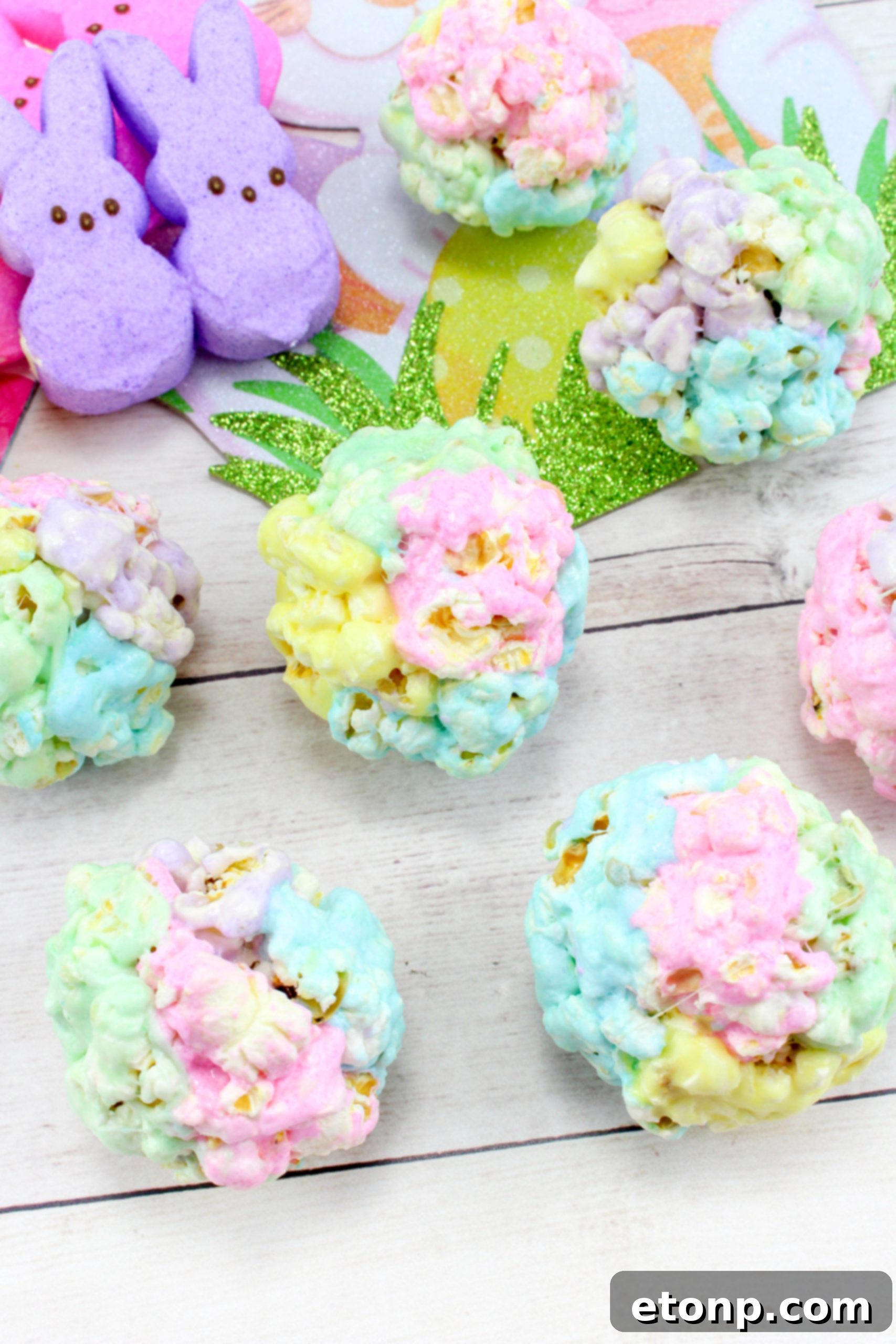 A large pile of freshly made marshmallow popcorn balls, showing the variety of colors and gooey texture, ready to be served.
